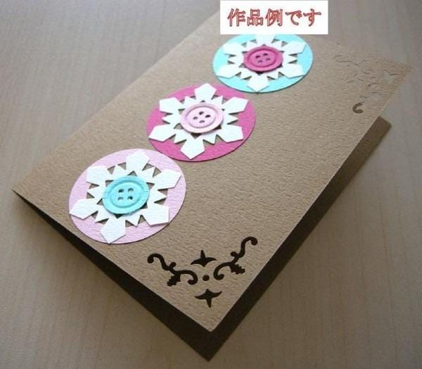 A handmade greeting card with three circular designs made from paper, featuring buttons as the central element.