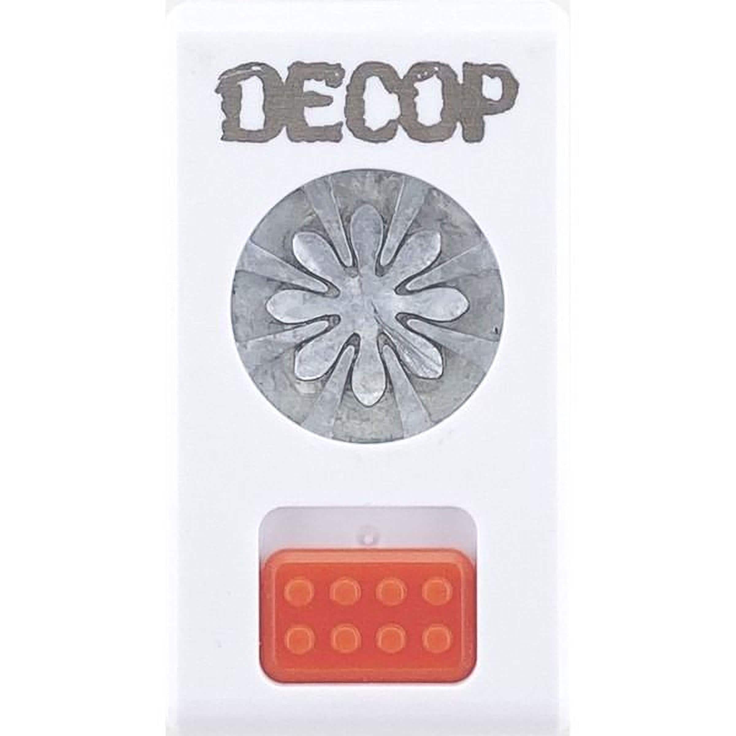 a white object with a silver flower-like design on it, and there is an orange object below it.