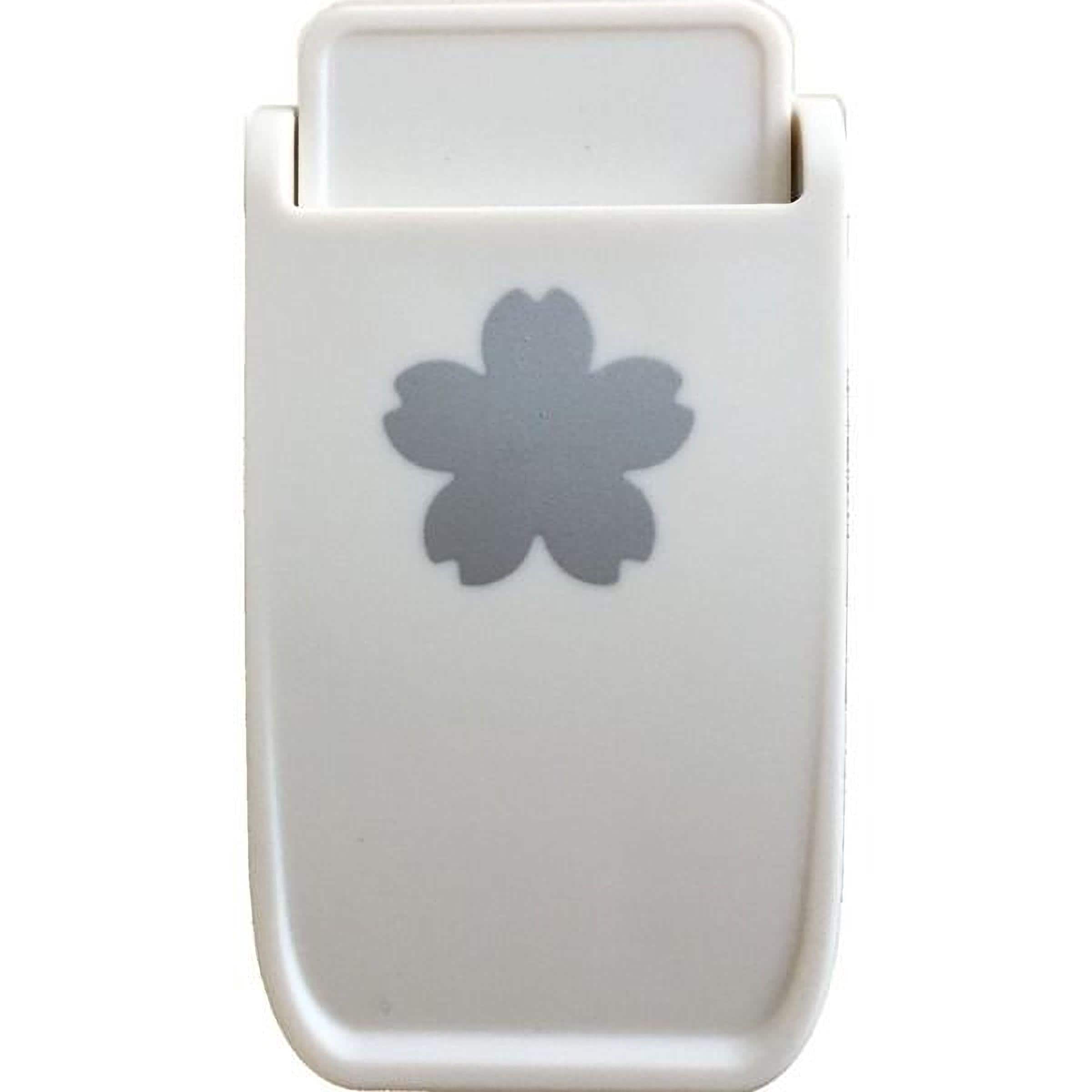 A white plastic object with a gray flower-shaped design on it.