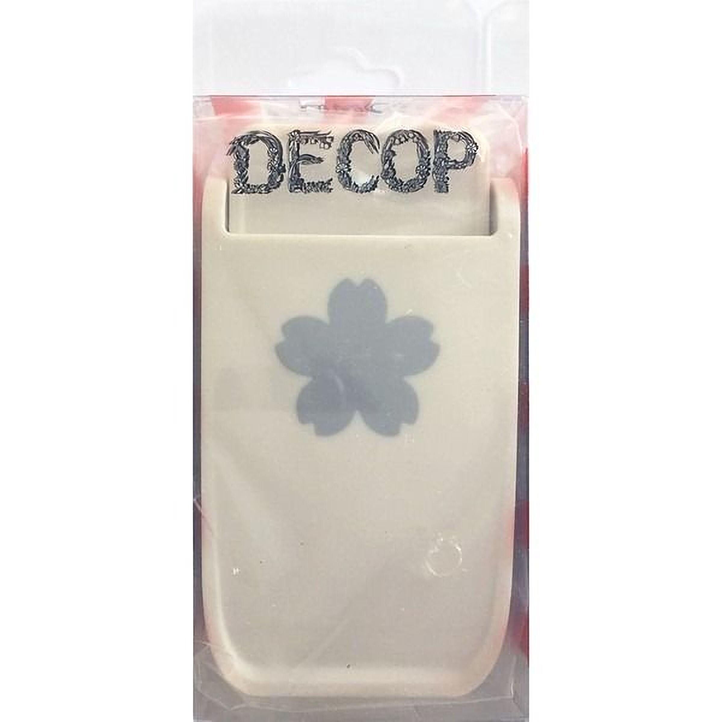 a white plastic object with a black flower design on it, which appears to be a product packaging.