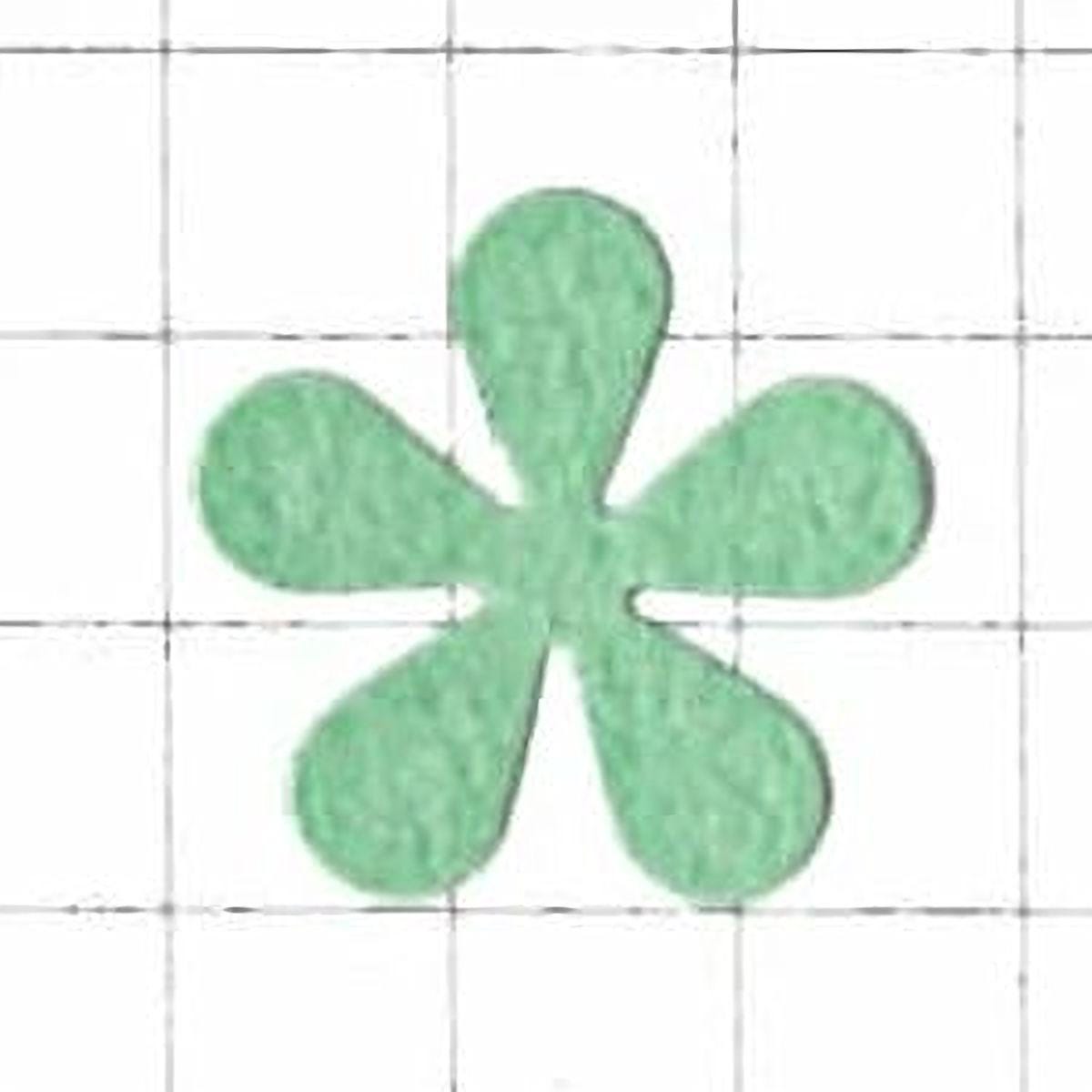A green felt flower-shaped object is centered against a white grid background.