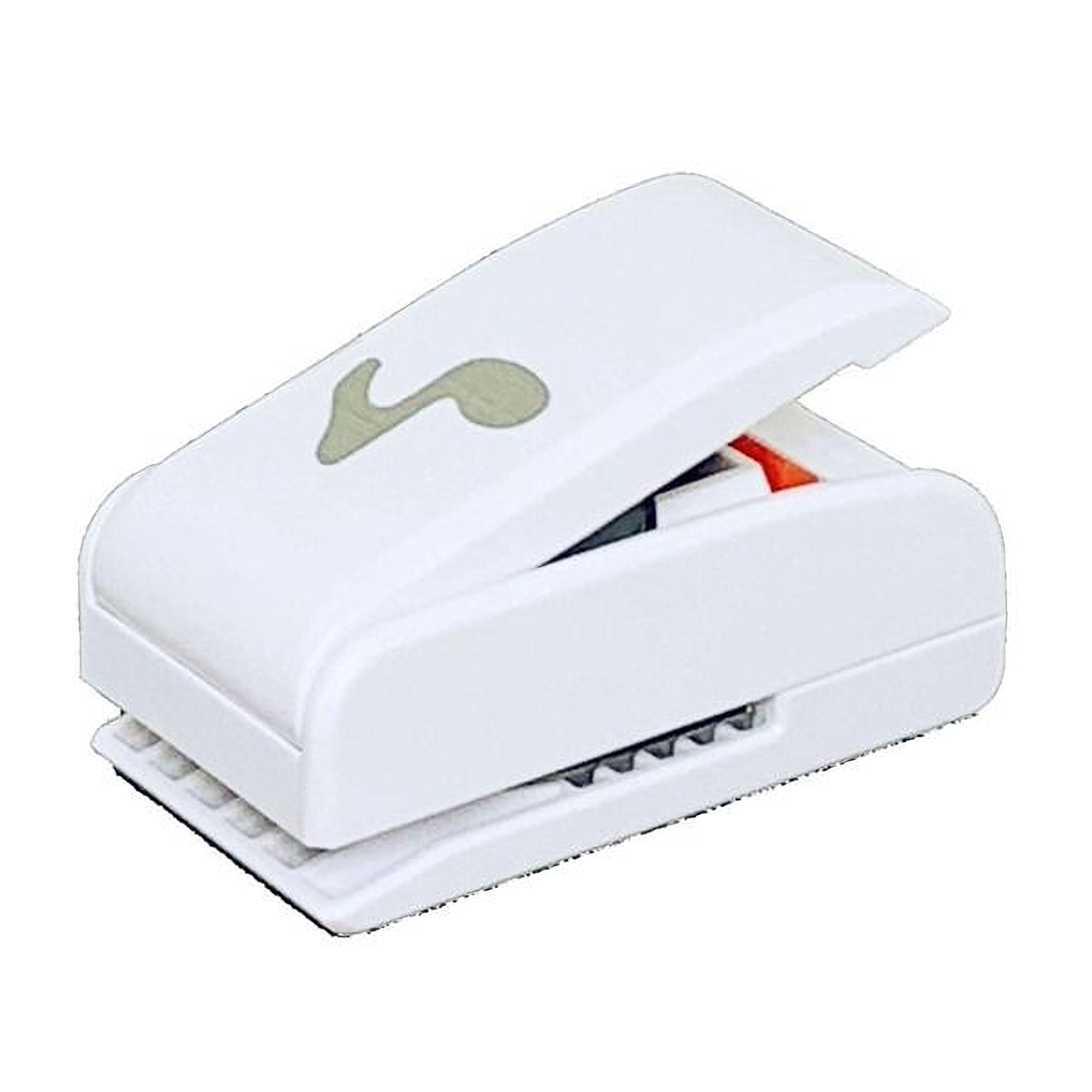 A white plastic hole puncher with a musical note design on it.