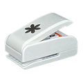 A white plastic hole puncher with a black flower design on the top.