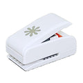 A white plastic hole puncher with a flower design on it.