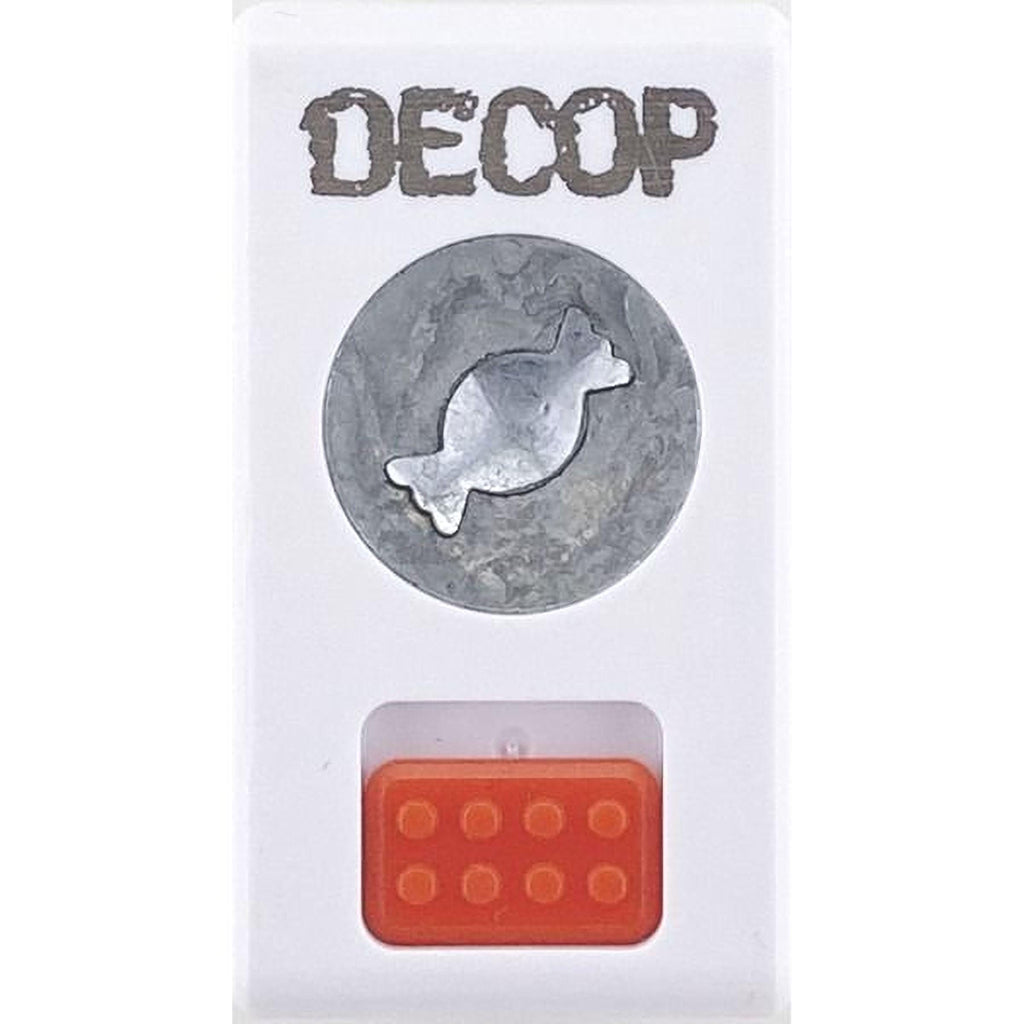 a white rectangular object with a silver circular emblem on it, and an orange rectangular object below it.