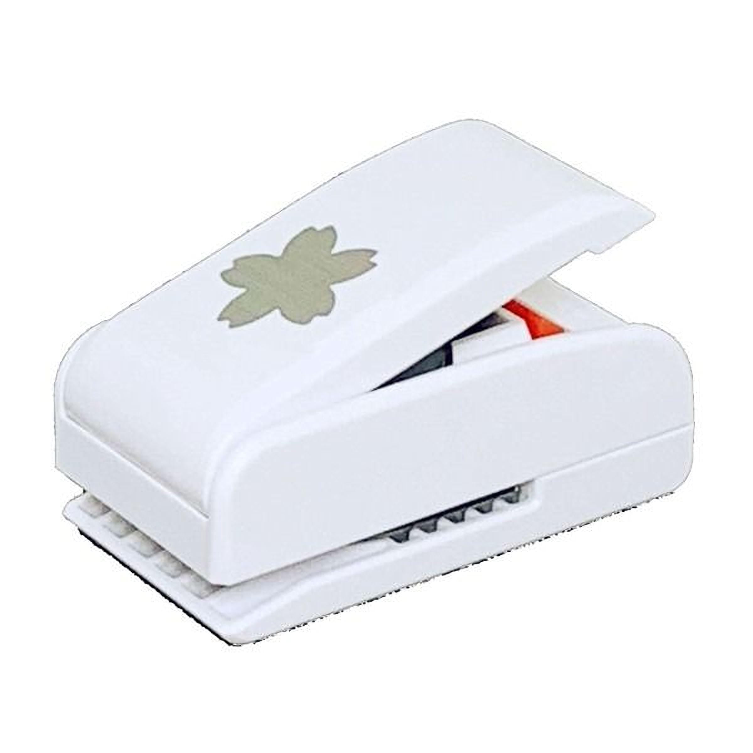 A white plastic hole puncher with a decorative leaf design on the top.