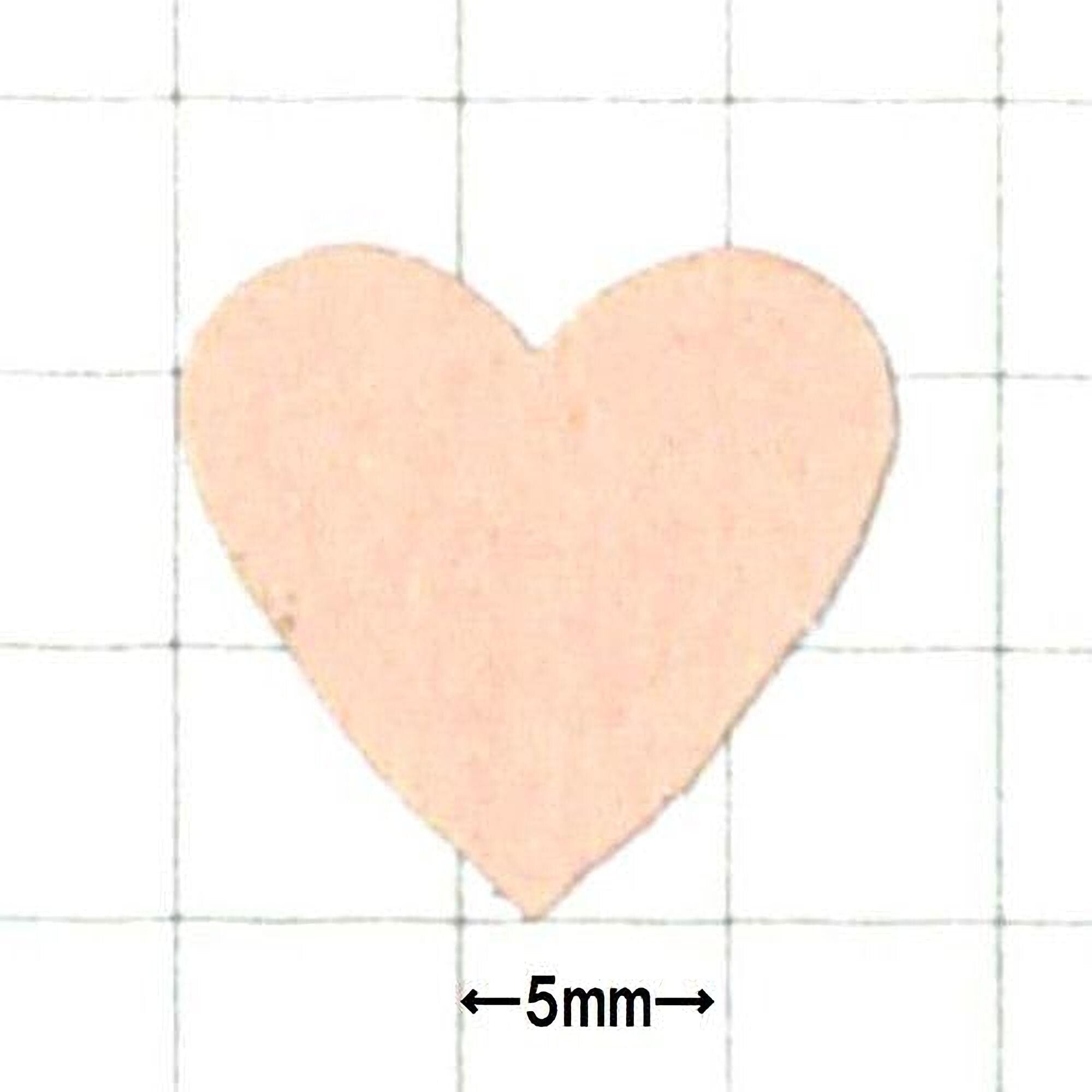 a heart-shaped object, which appears to be a small, light-colored material.