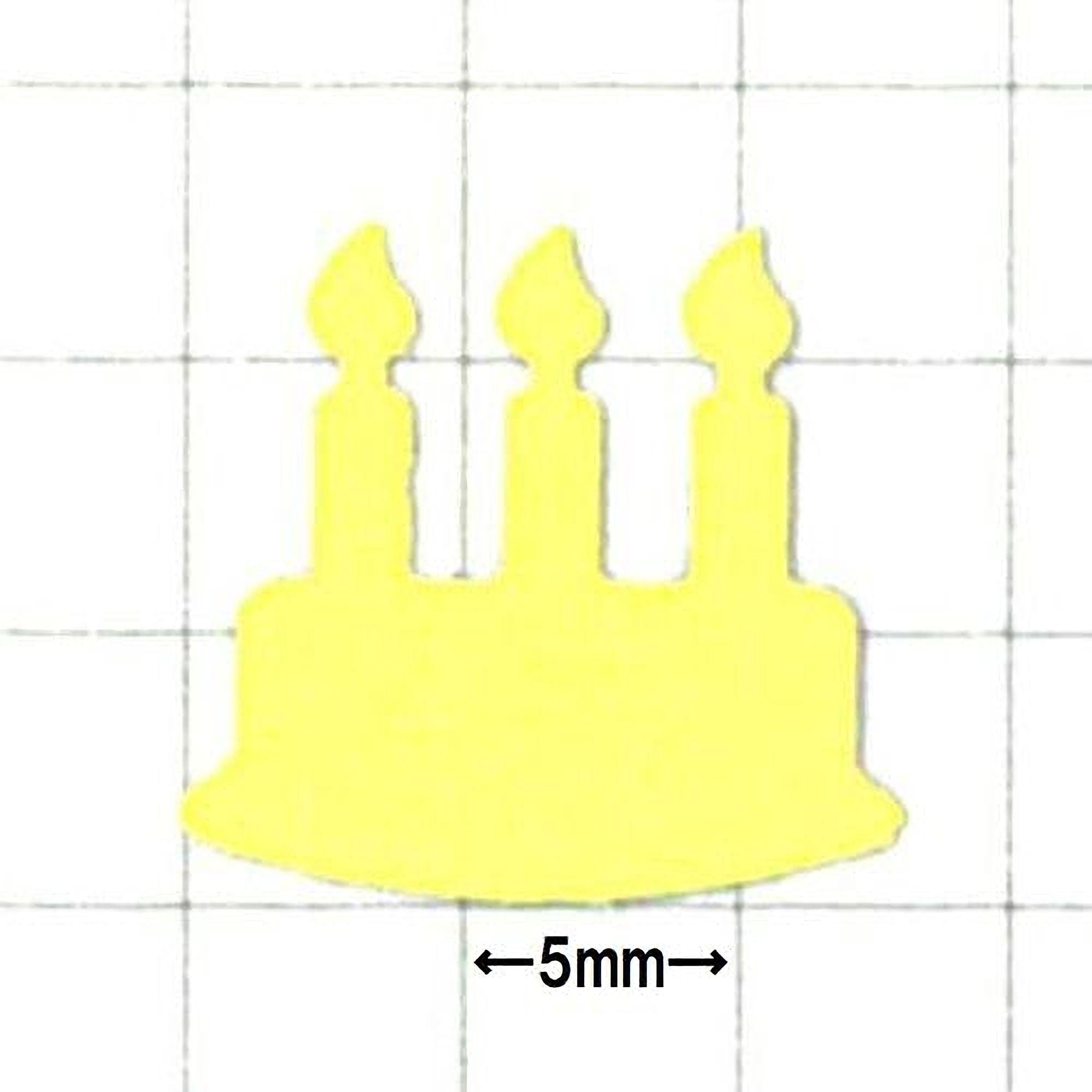 A yellow cake-shaped object with three candles on top, placed against a grid background.