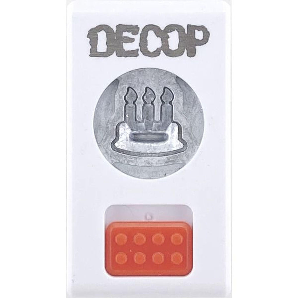 a white plastic object with a silver circular cutout in the center, which appears to be a candle holder. Below the candle holder, there is a red plastic block with a hole in it.