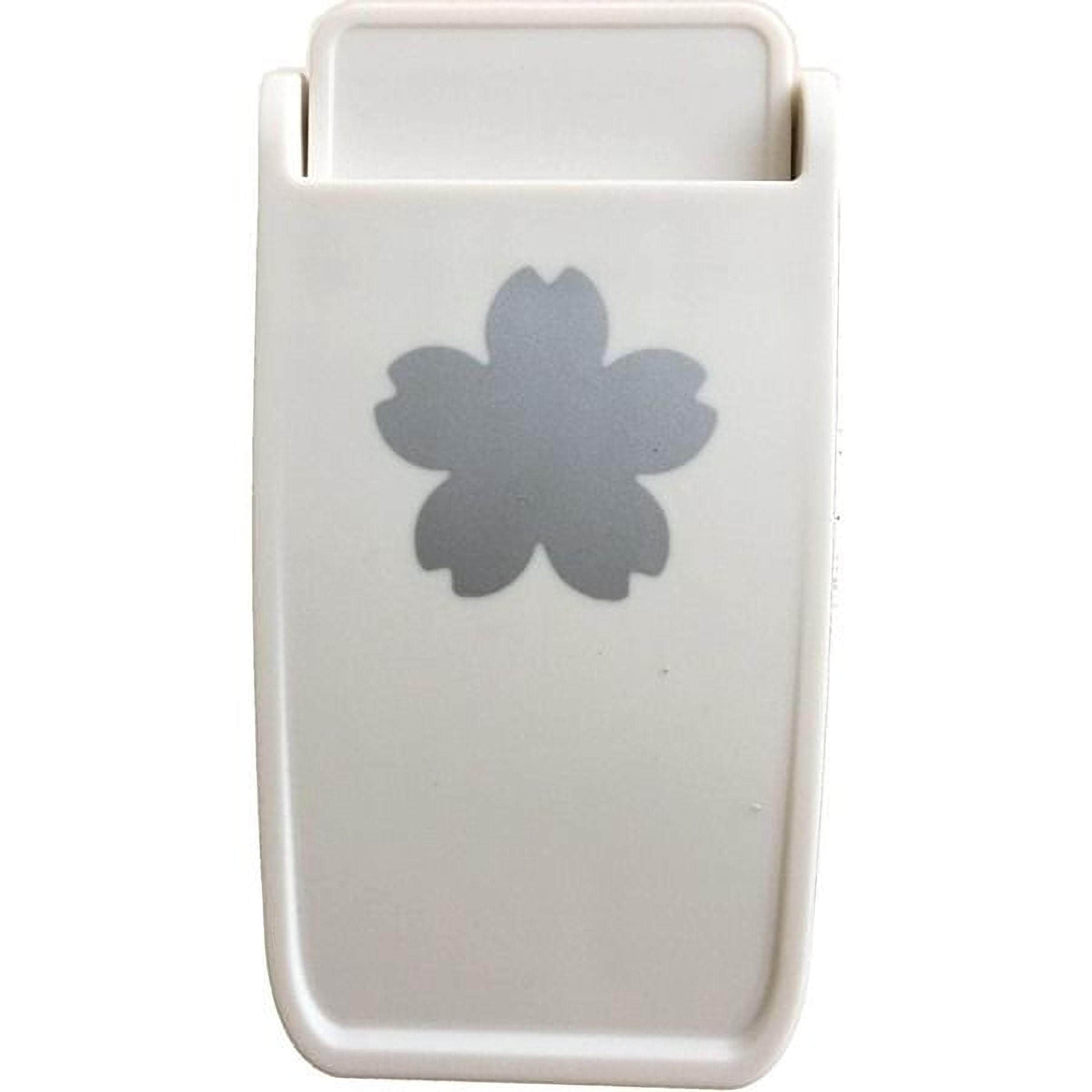 A white plastic object with a silver flower-shaped design on it.