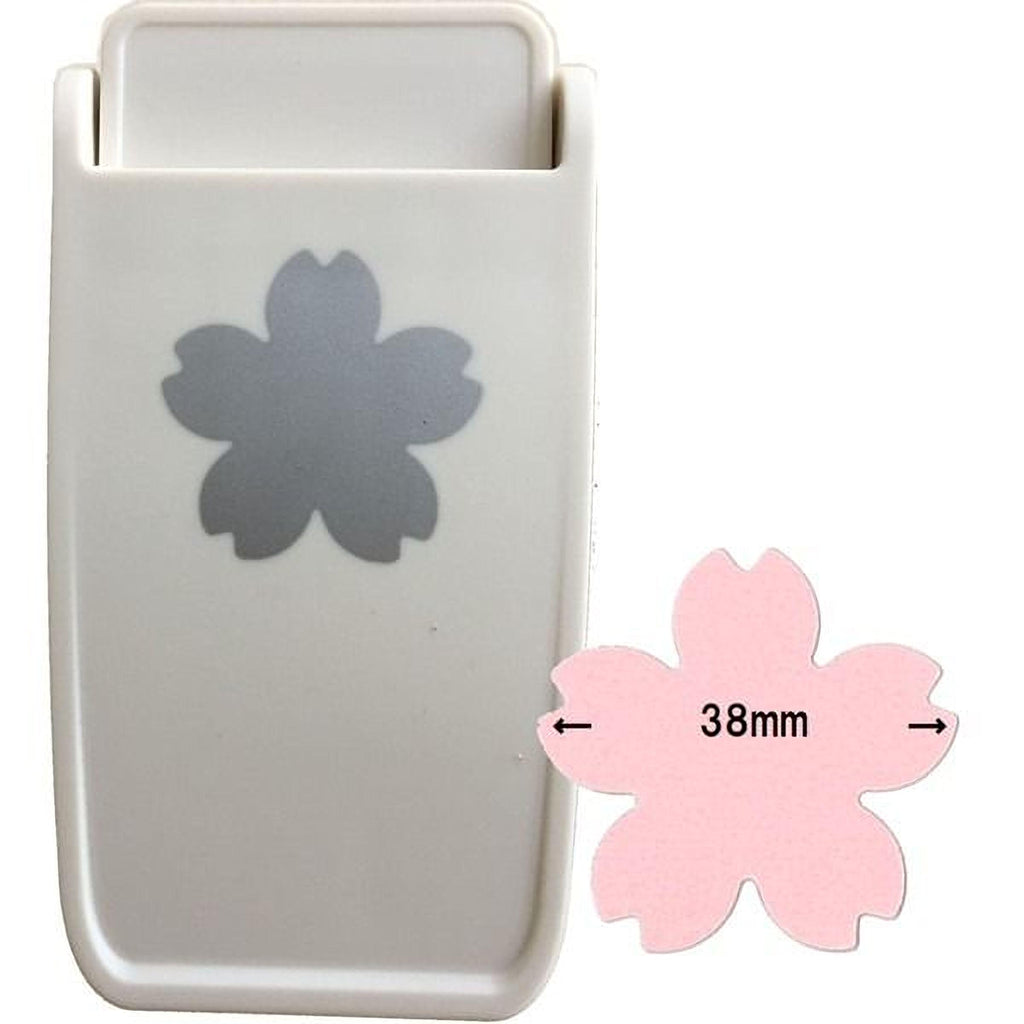 a white plastic tool with a gray flower-shaped hole on it, and there is a pink flower-shaped hole next to it.