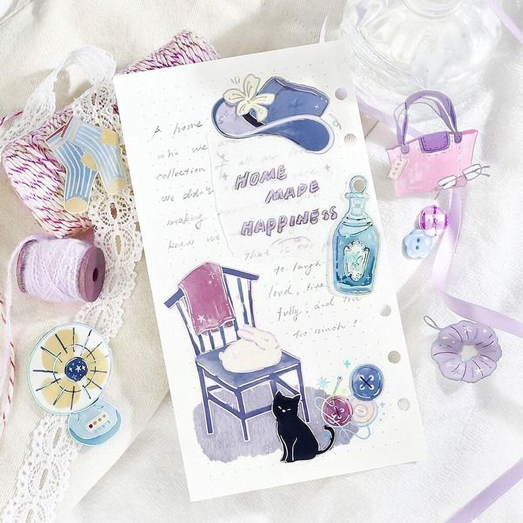 The image is a scrapbook page with various decorative elements, including a hat, a purse, a cat, and other home-related items. The page also contains handwritten text and illustrations, creating a personal and creative atmosphere.