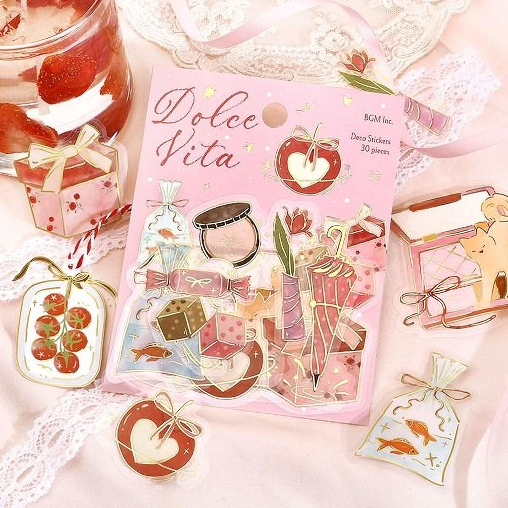 a pink book with a variety of stickers and illustrations on the cover, including a small glass jar, a pink ribbon, and other decorative elements.
