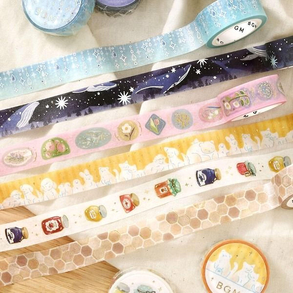 a variety of colorful and patterned washi tape rolls arranged on a surface.