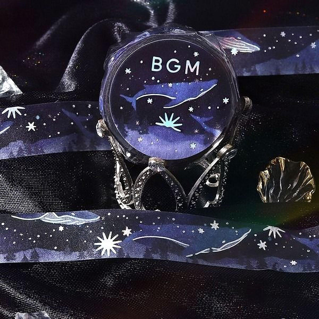 a round, blue watch with a starry night sky design, placed on a black surface.