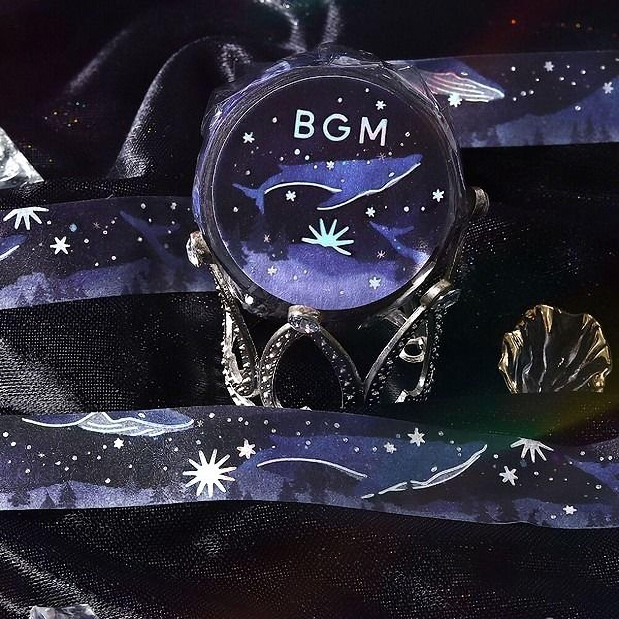 a round, blue watch with a starry night sky design, placed on a black surface.
