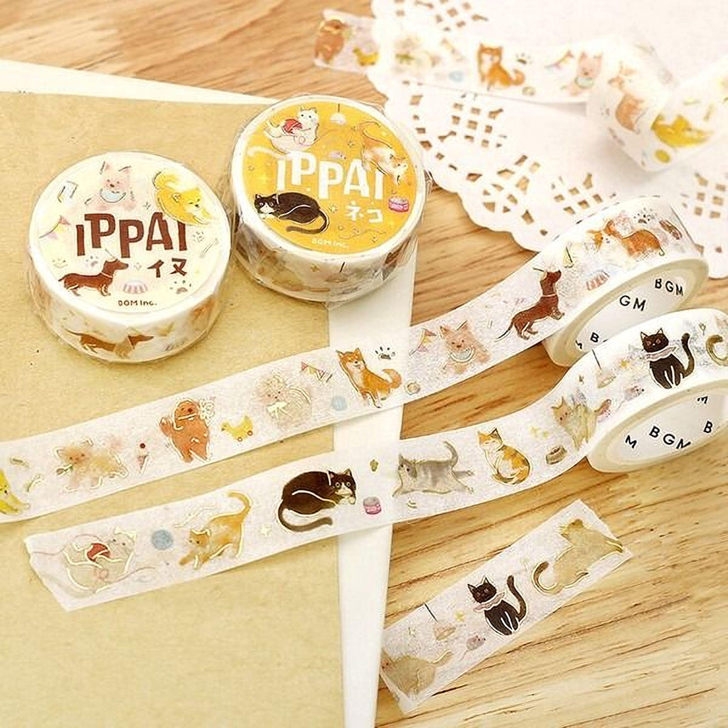 a collection of cat-themed items, including two rolls of Tippai brand washi tape and several pieces of paper with cat designs.