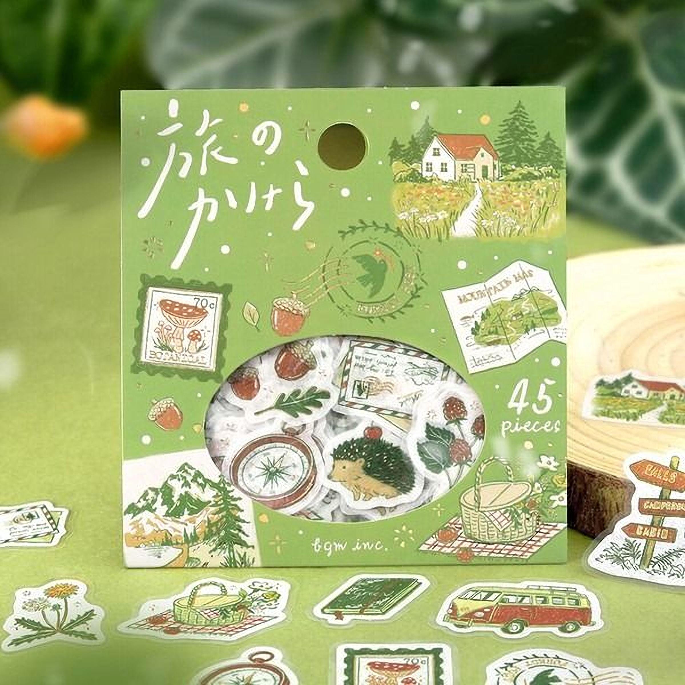 A green box containing a collection of stickers with various illustrations, including a house, trees, and other nature-themed elements.