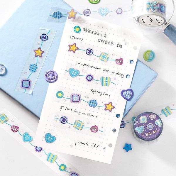 a piece of paper with a workout check-in list, surrounded by various craft supplies and embellishments, such as star-shaped stickers and heart-shaped stickers.
