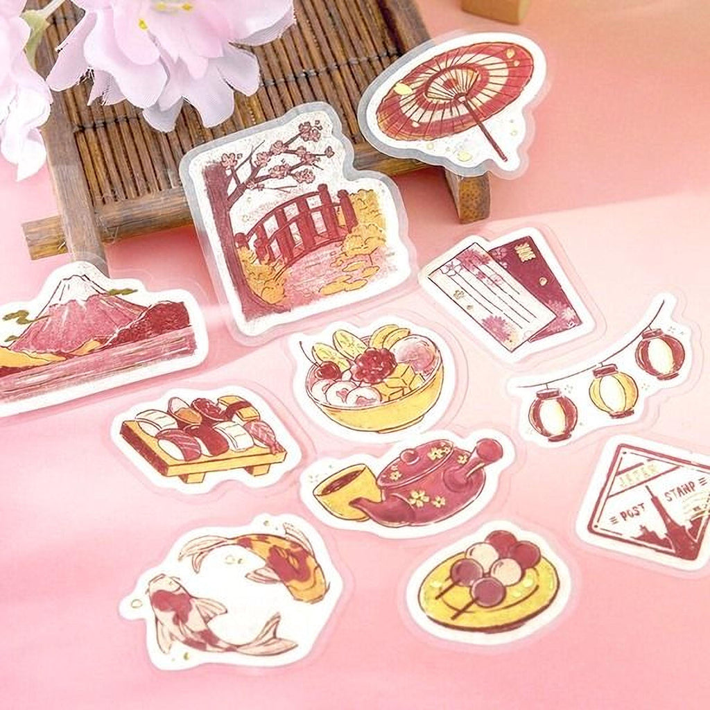 a collection of colorful stickers depicting various Japanese-inspired objects and scenes, including a bridge, a bowl of fruit, a teapot, and a koi fish.