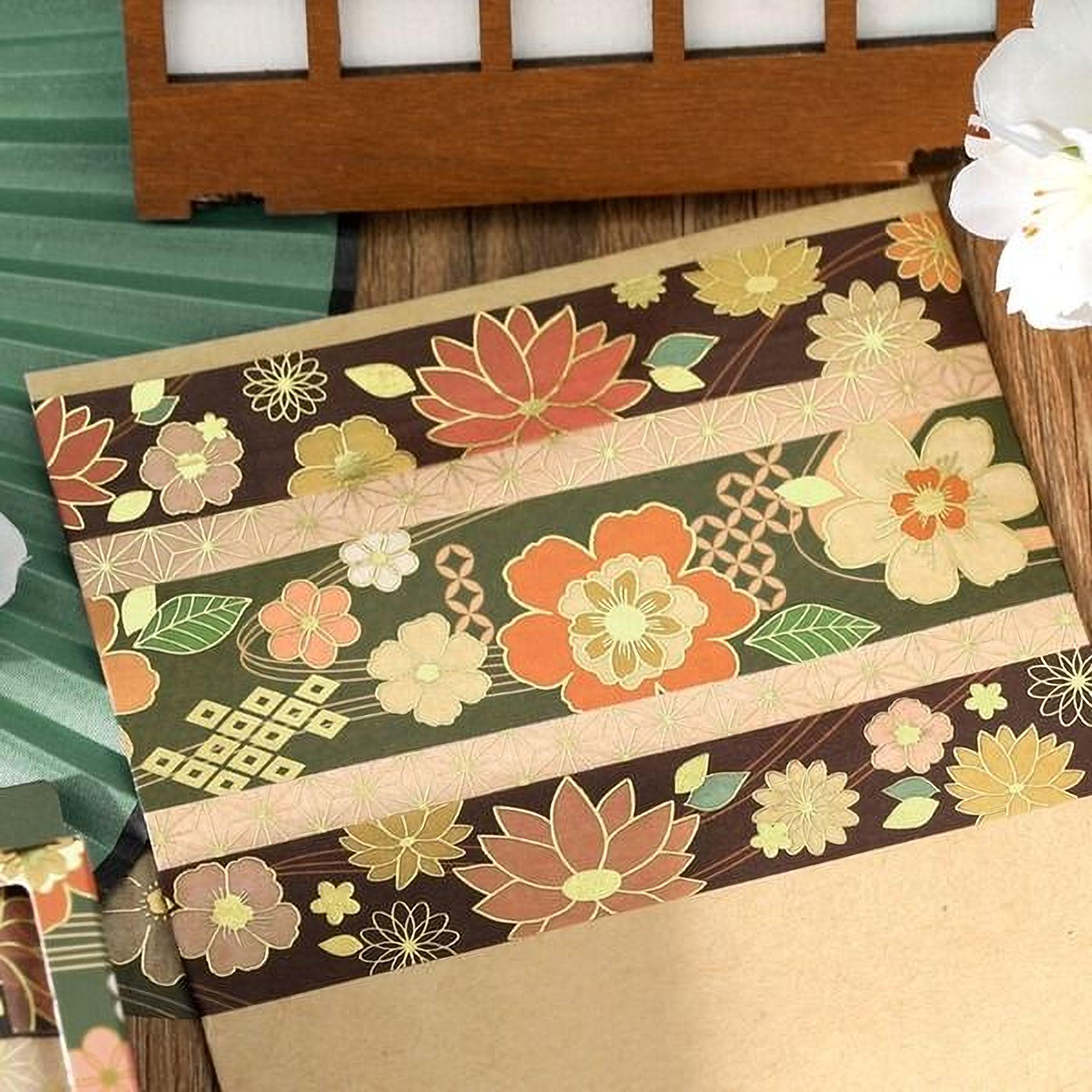a decorative paper with a floral pattern, including various types of flowers and leaves in shades of brown, green, and orange. The paper appears to be a decorative card or piece of art, with the flowers and leaves arranged in a visually appealing manner.