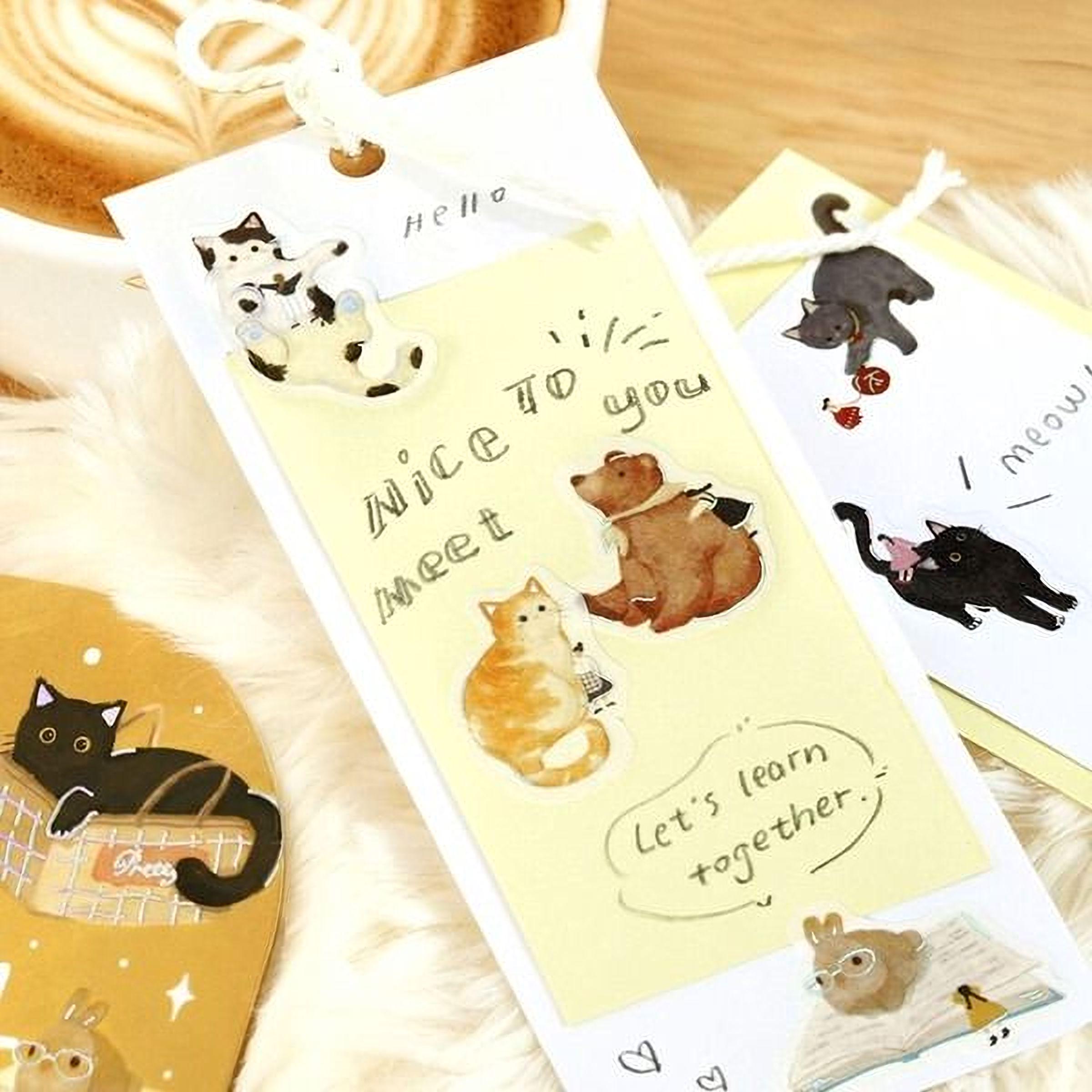 a collection of stickers and cards with various cat illustrations, including a yellow card with a message that says " Nice to meet you" and a black cat sticker.