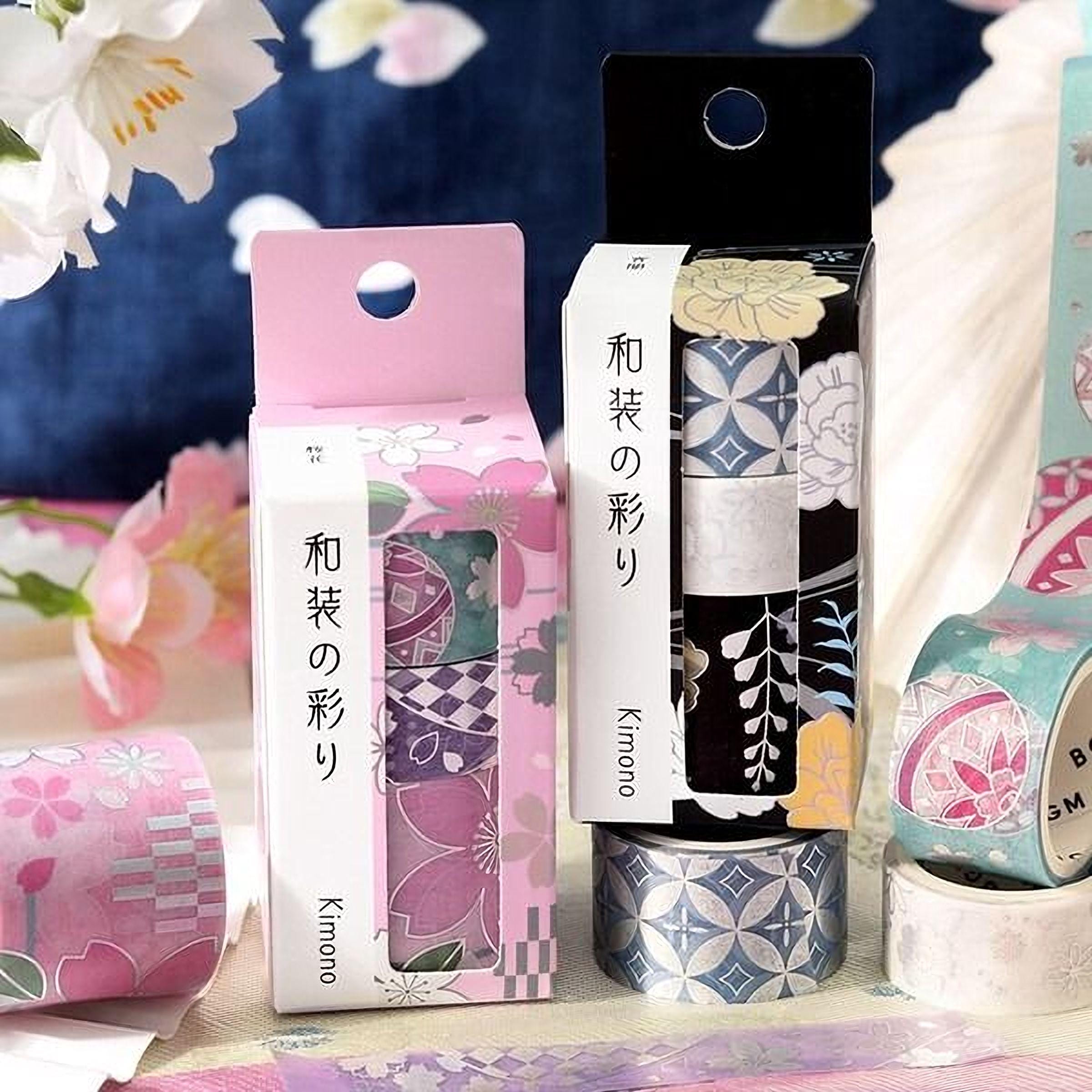two boxes of decorative washi tape, each with a unique floral pattern, placed on a table with a floral background.