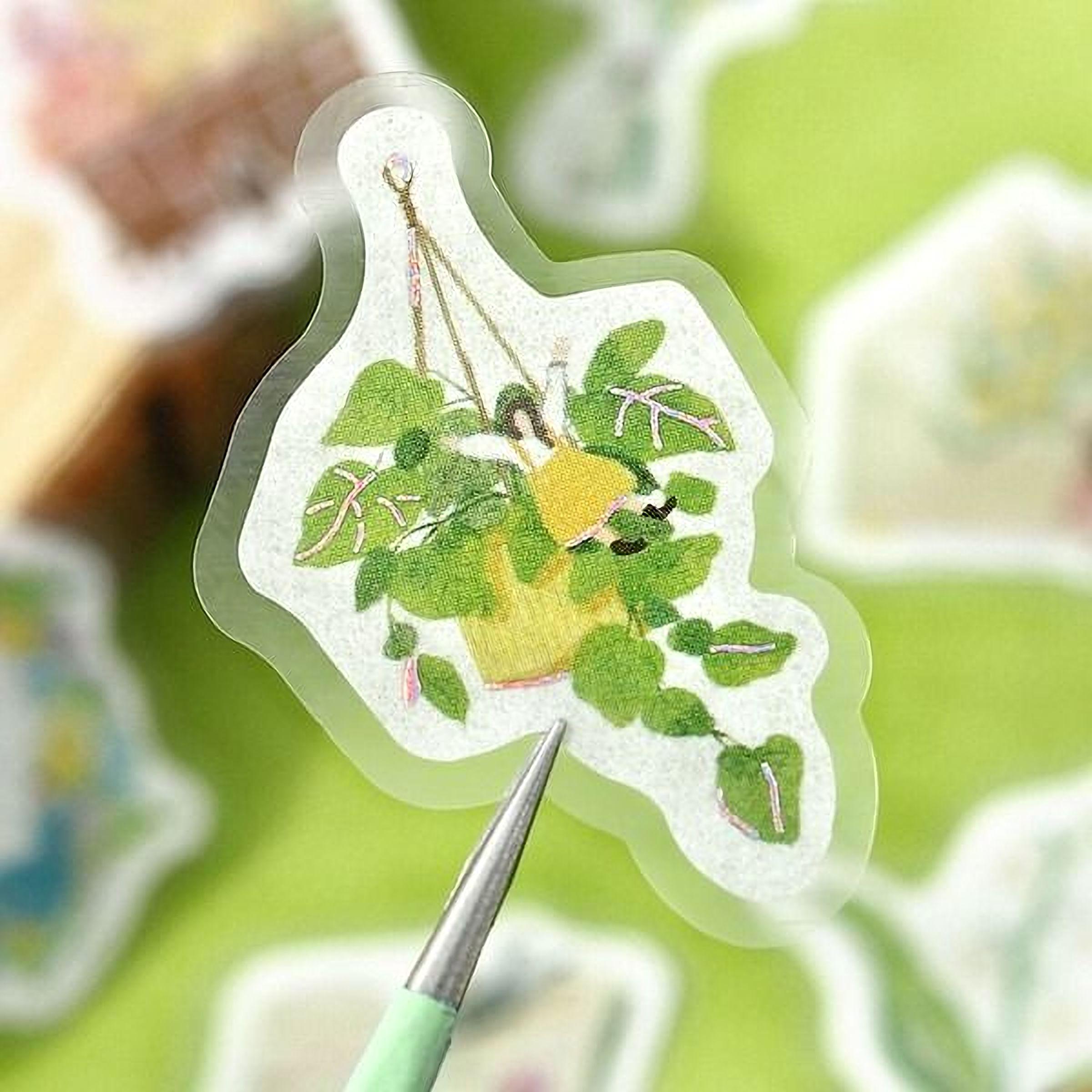 A sticker with a potted plant and a person sitting in it, set against a green background.