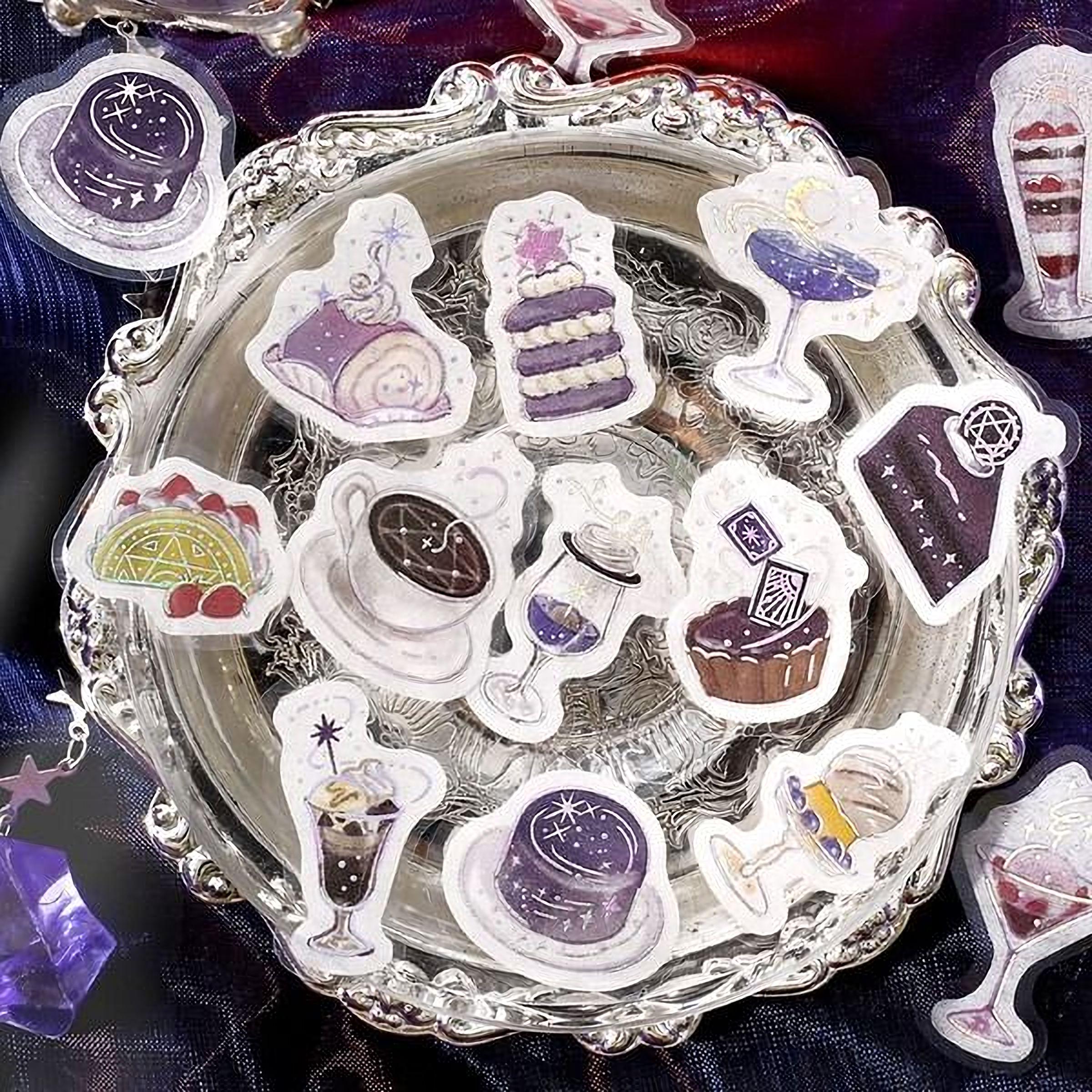 a silver tray with various desserts and drinks, including cakes, glasses, and other sweet treats, arranged on it.