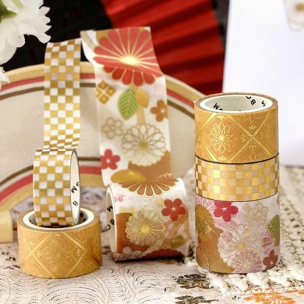 an assortment of colorful and patterned tape rolls, including gold and white checkered tape, floral designs, and other decorative elements.