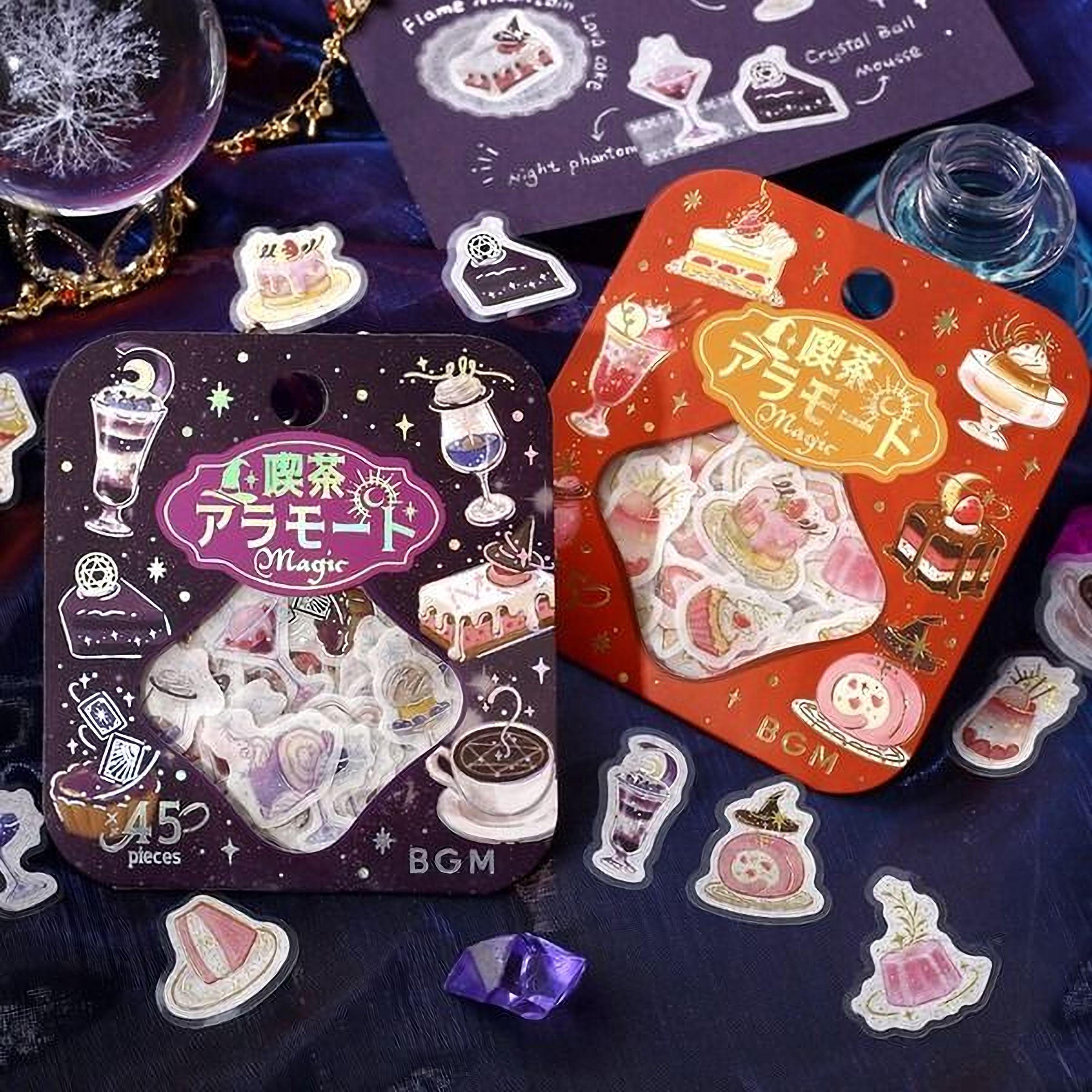 two packages of stickers with various desserts and food items, including cakes, ice cream, and other sweet treats. The packages are placed on a dark surface, and there are additional stickers scattered around them.