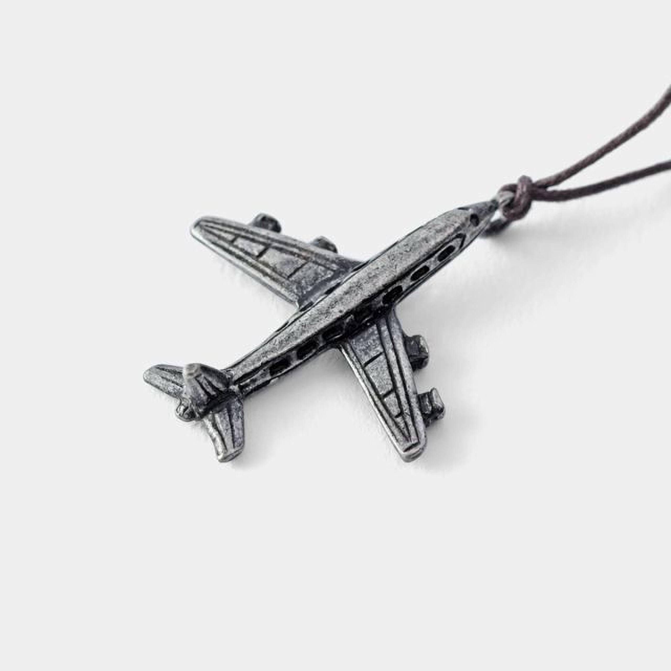 A silver-colored metal airplane pendant is shown against a white background.