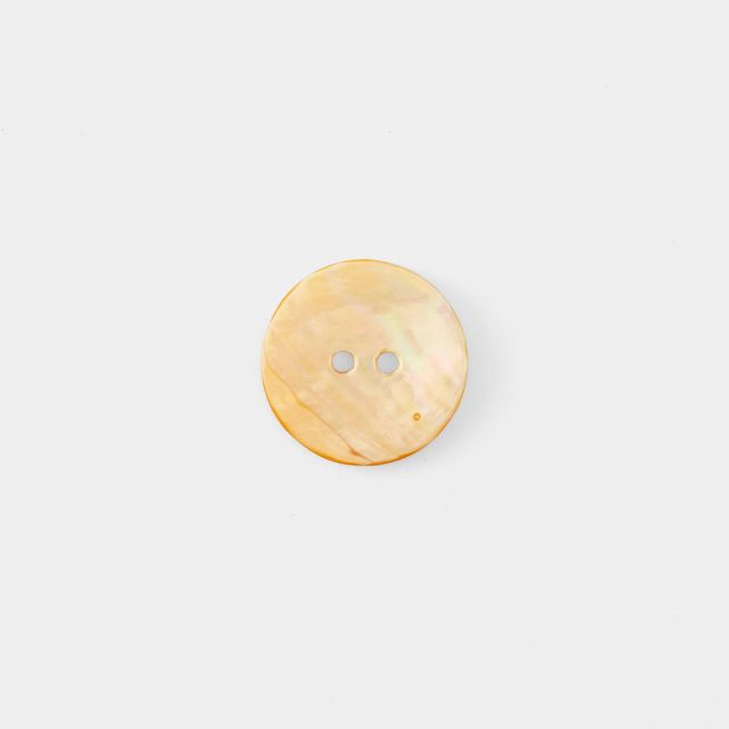 A single, round, light-colored button is shown against a plain white background.