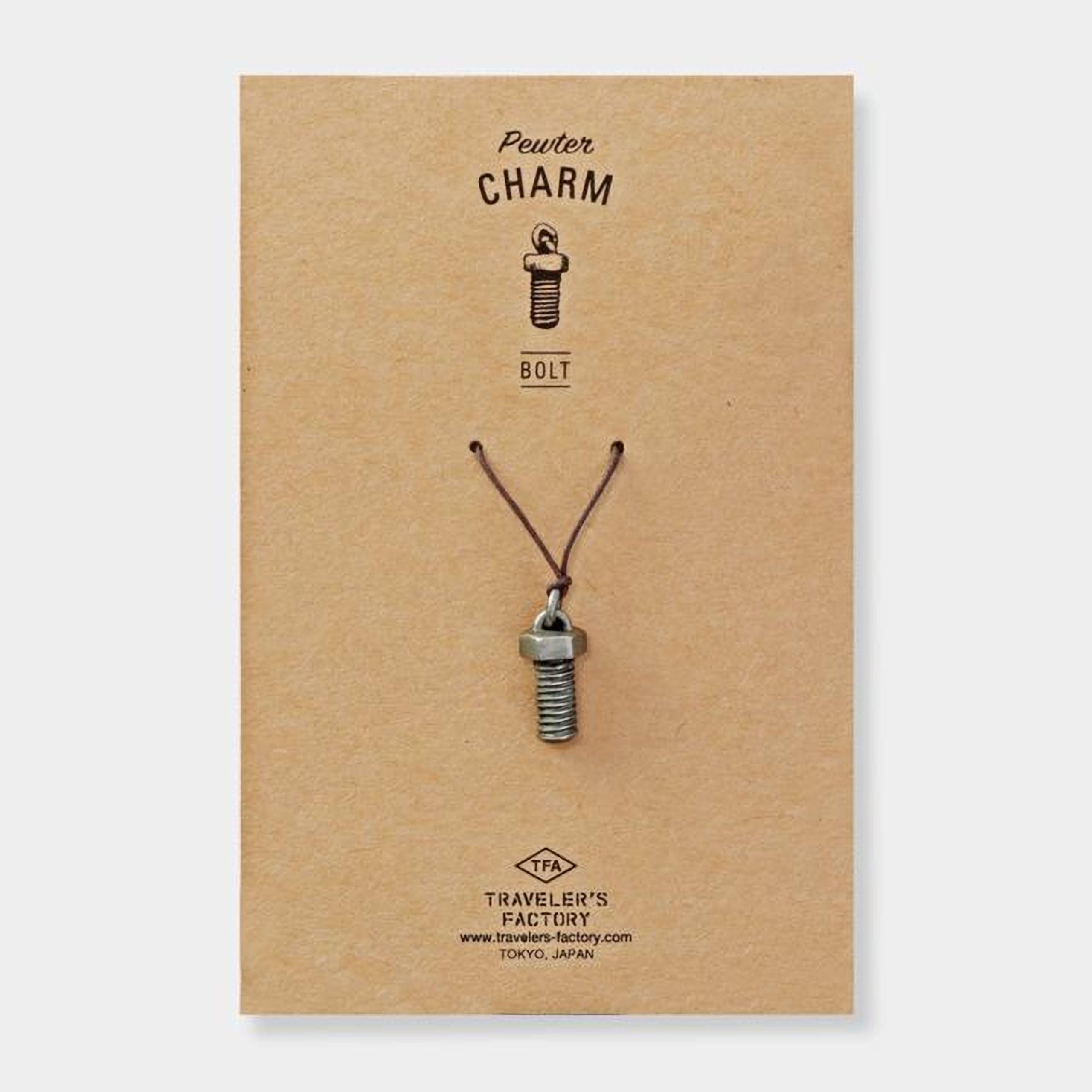 A pendant made of a small metal bolt is shown on a brown cardboard background.