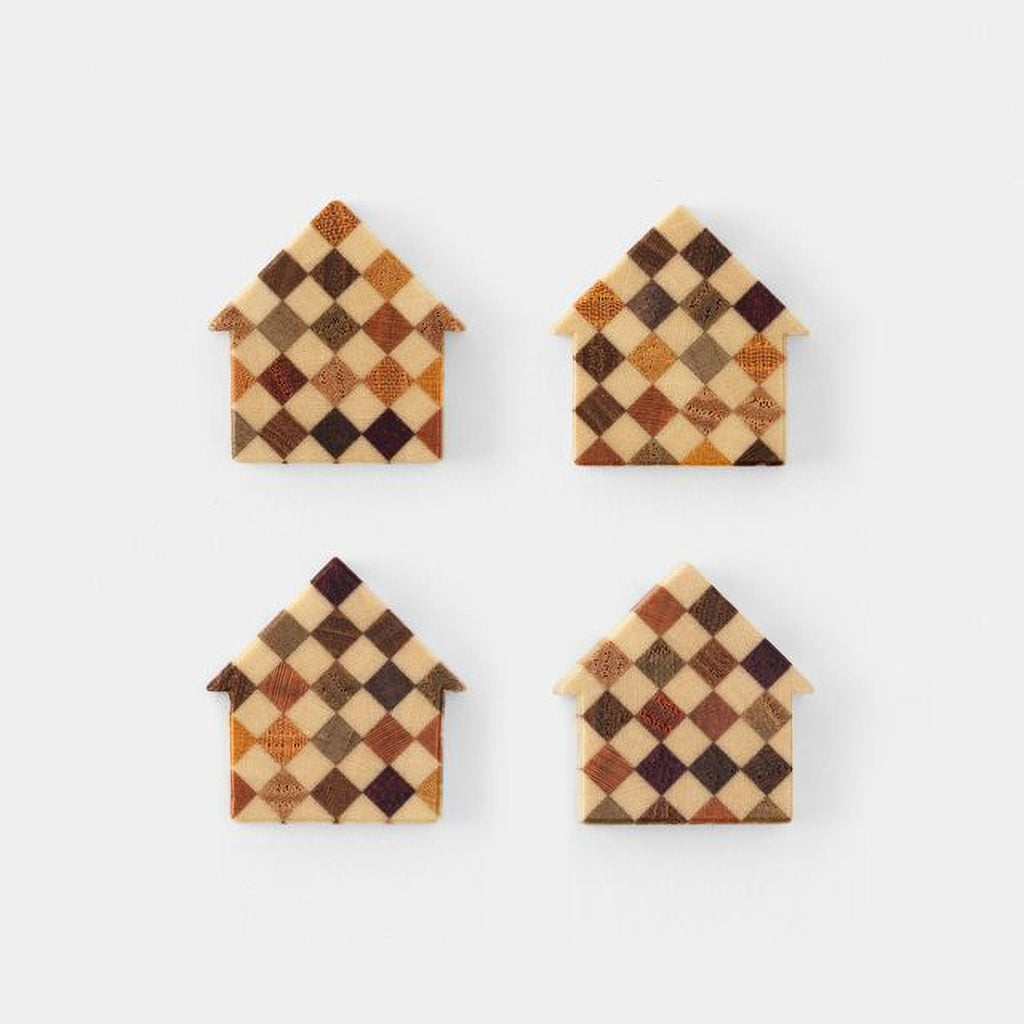four small, checkered-patterned house-shaped objects, each with a unique color and design.