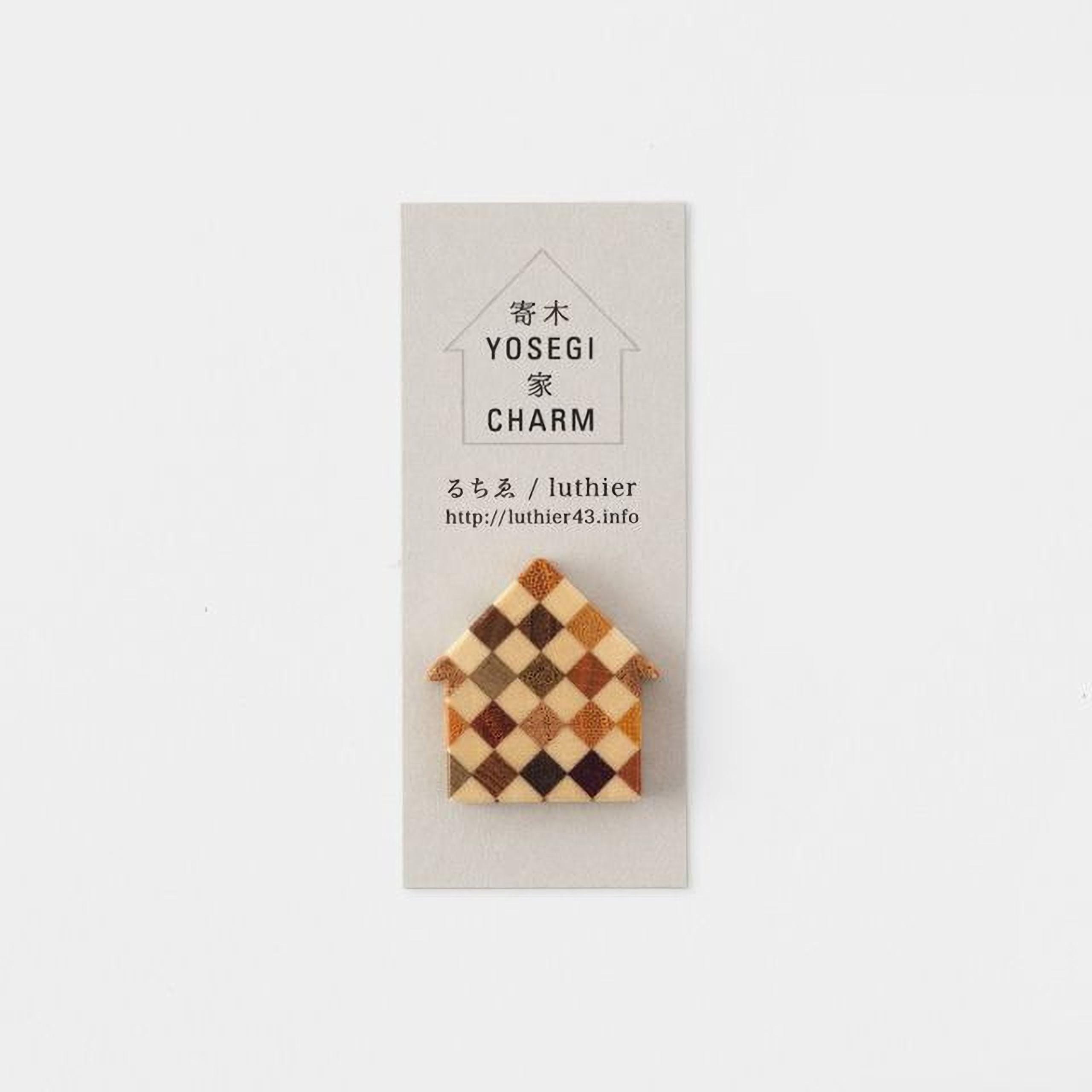 A small, wooden house-shaped pin is displayed against a light background.