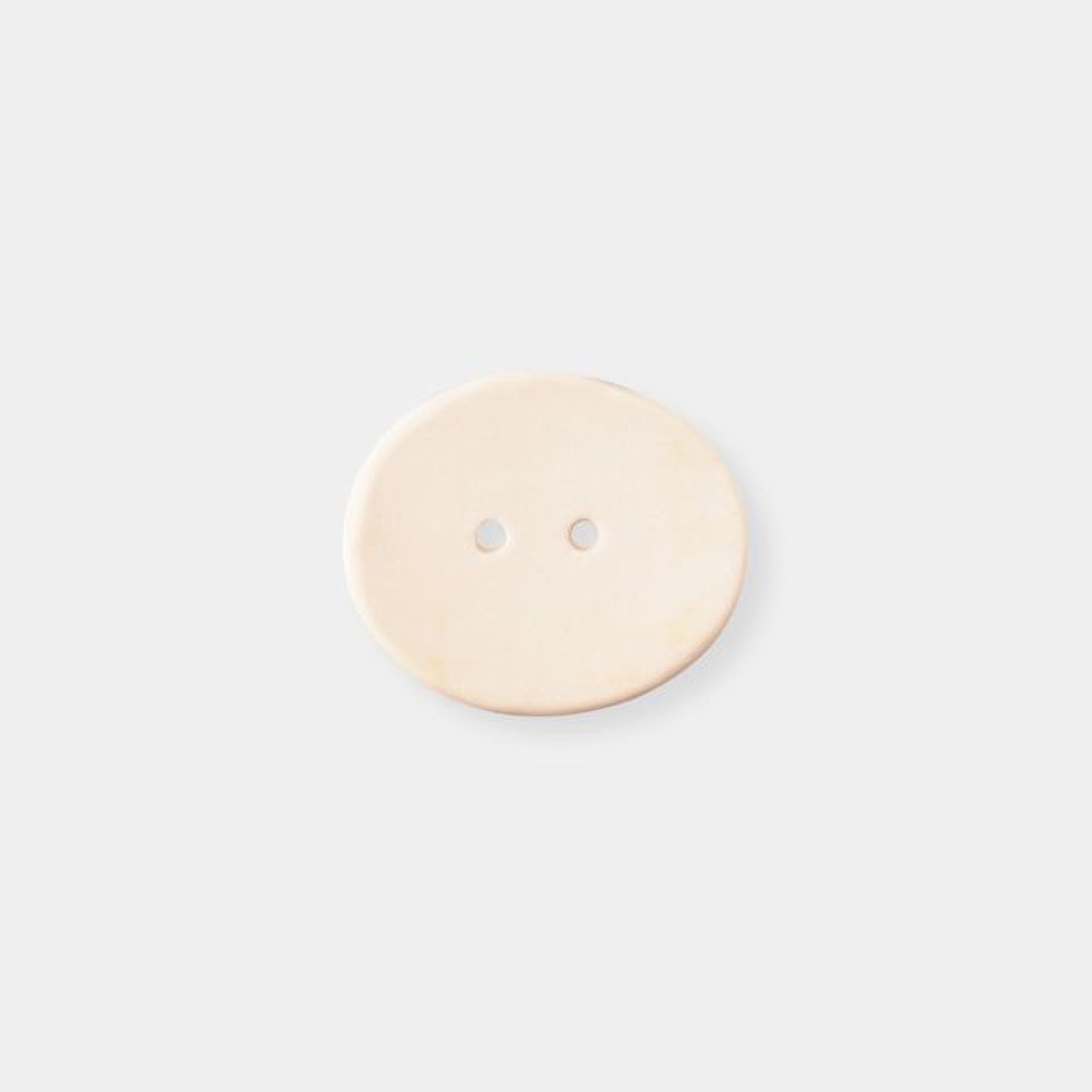 A single light-colored button with two holes is shown against a plain white background.