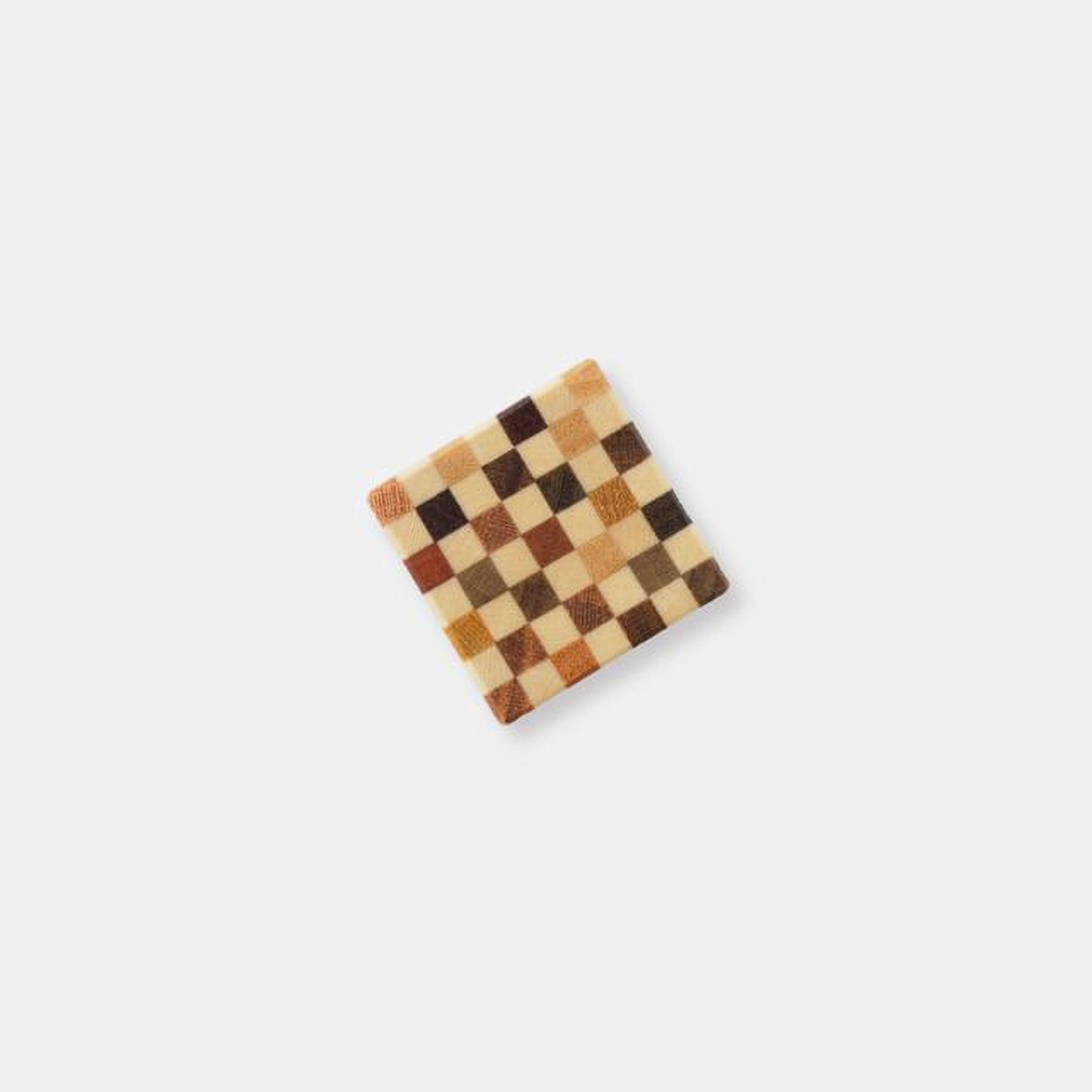 A square-shaped coaster with a checkered pattern of brown and beige squares.