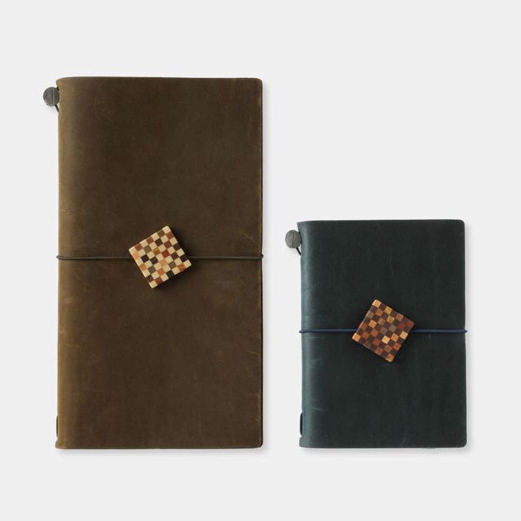Two leather-bound notebooks with checkered designs on the covers, one in a dark brown color and the other in a dark green color.