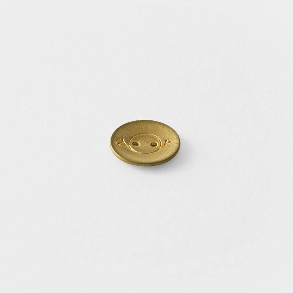 A single gold button with a smiley face design on it.