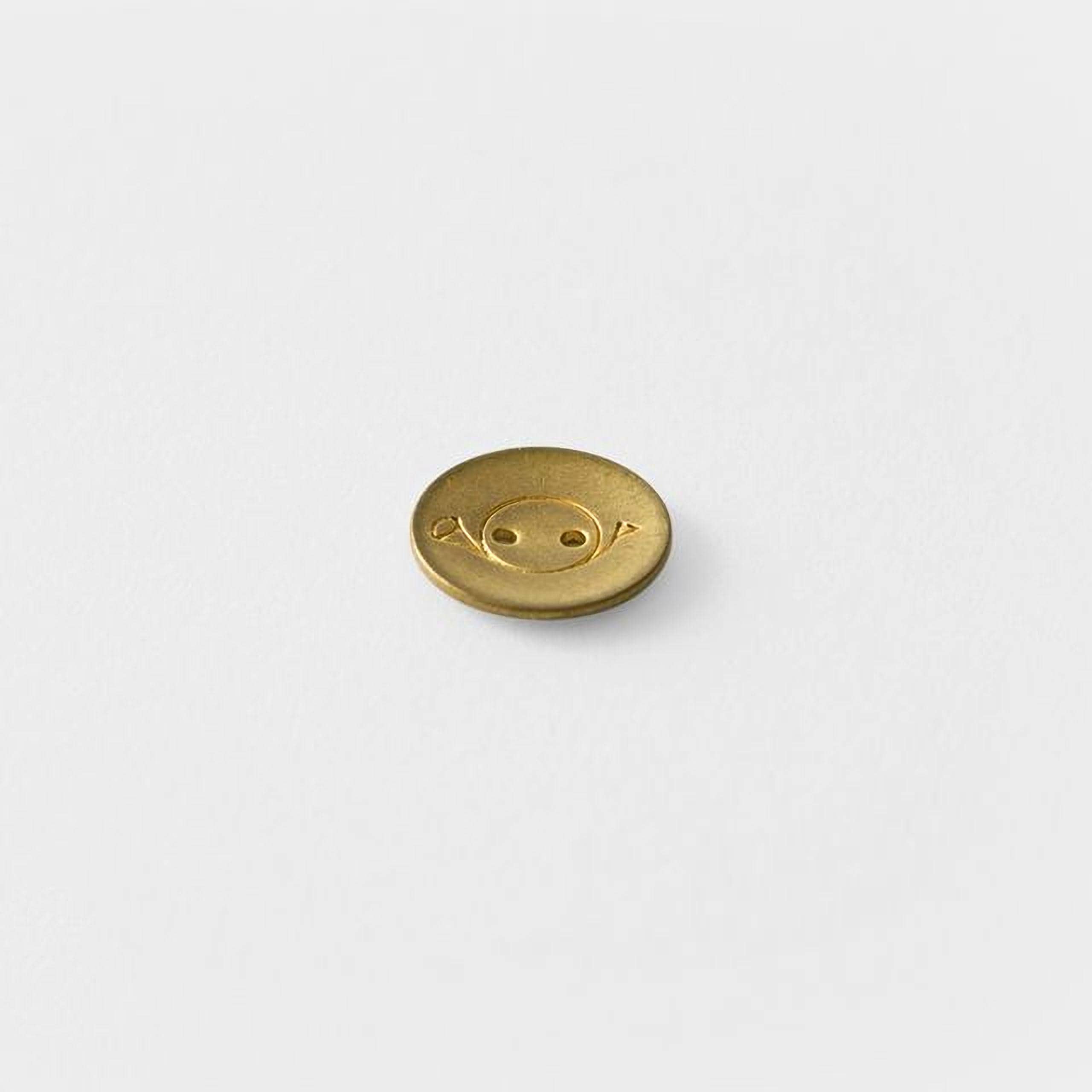 A single gold button with a smiley face design on it.