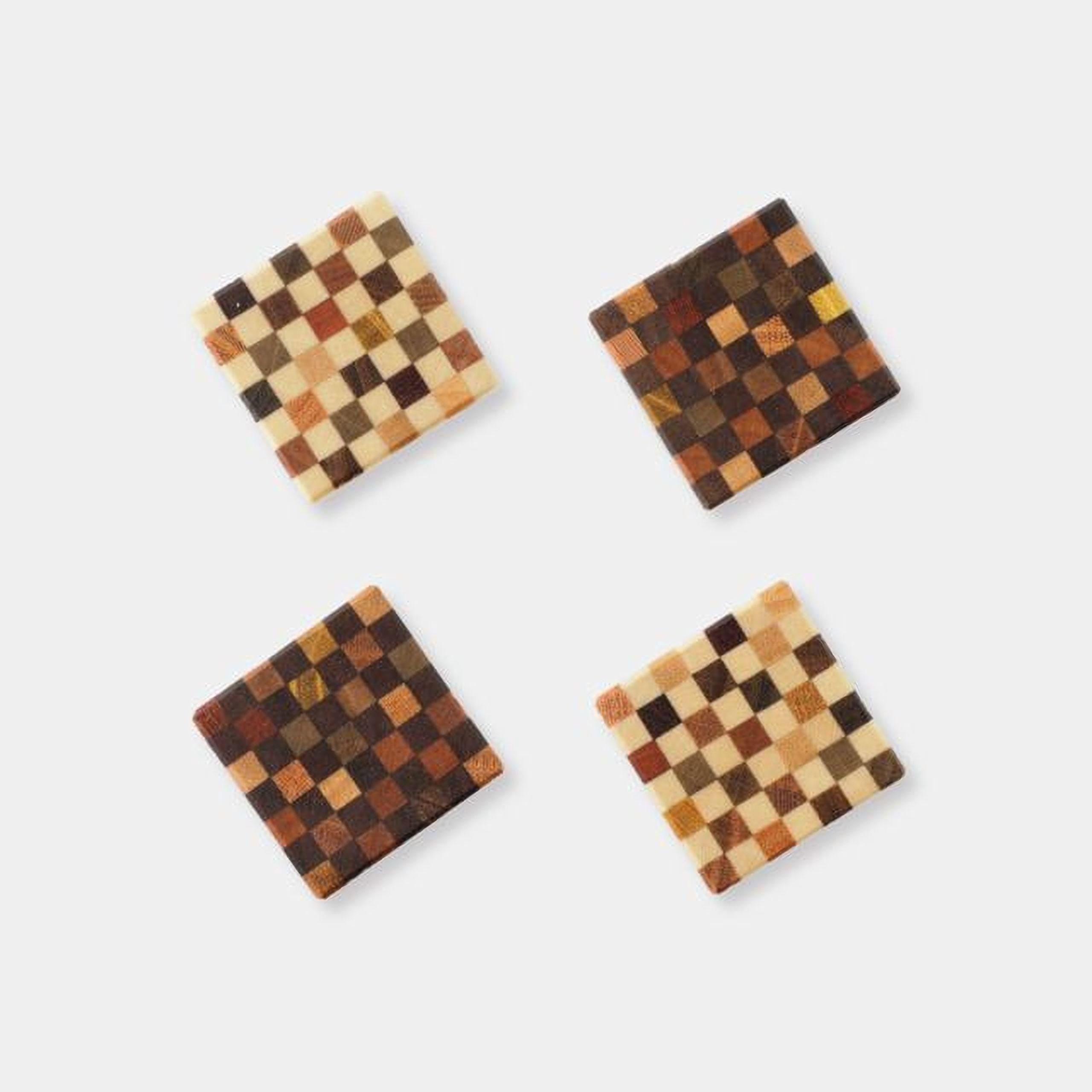 four square coasters with a checkered pattern, arranged in a square formation against a white background.