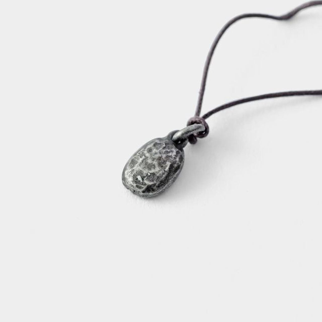 A silver pendant with a twisted cord is shown against a plain white background.