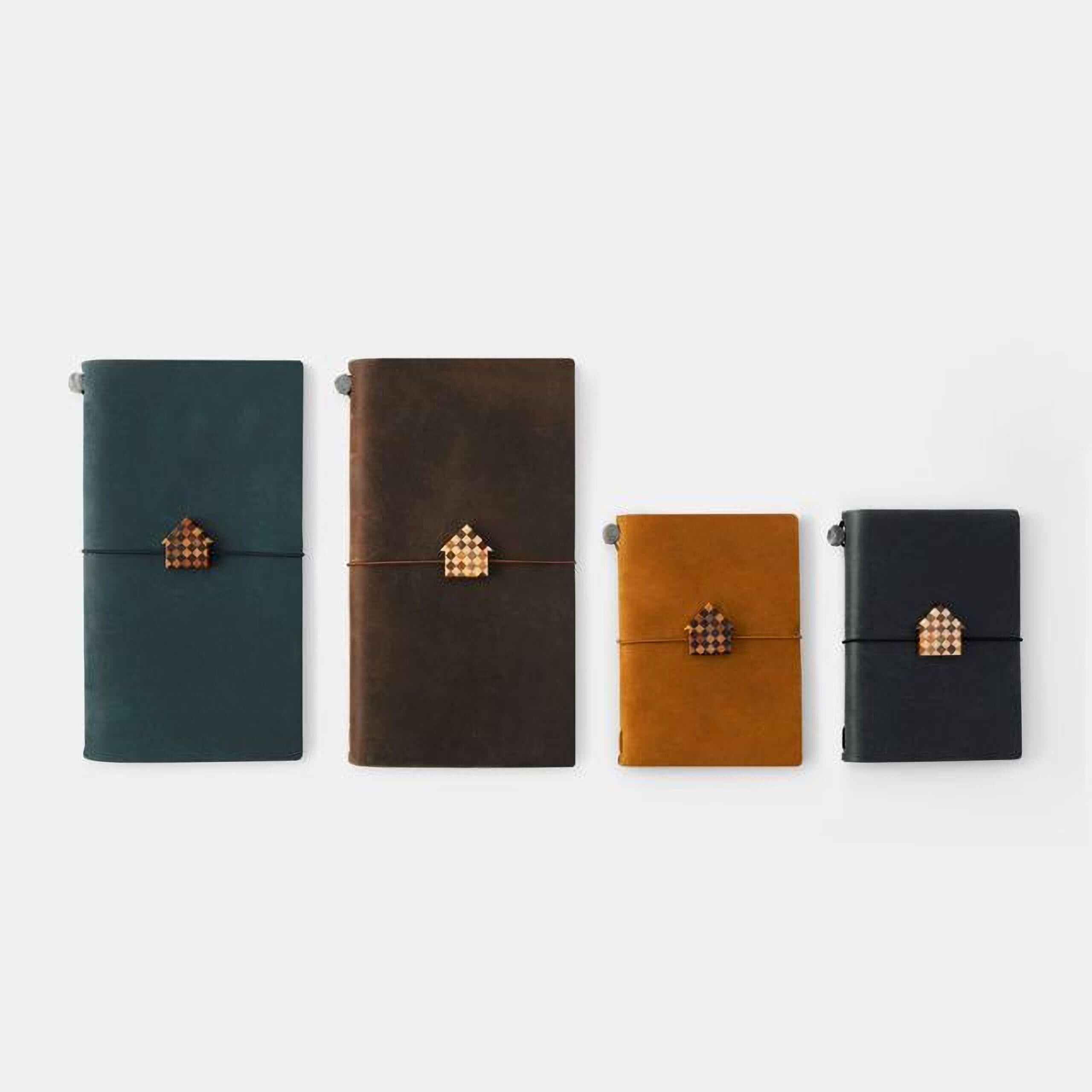 four different-sized notebooks with house-shaped charms attached to the bindings.