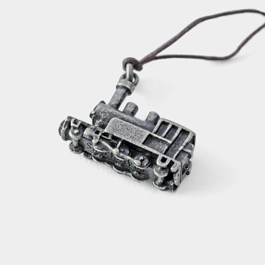 A silver-colored metal pendant in the shape of a train engine is shown against a plain white background.
