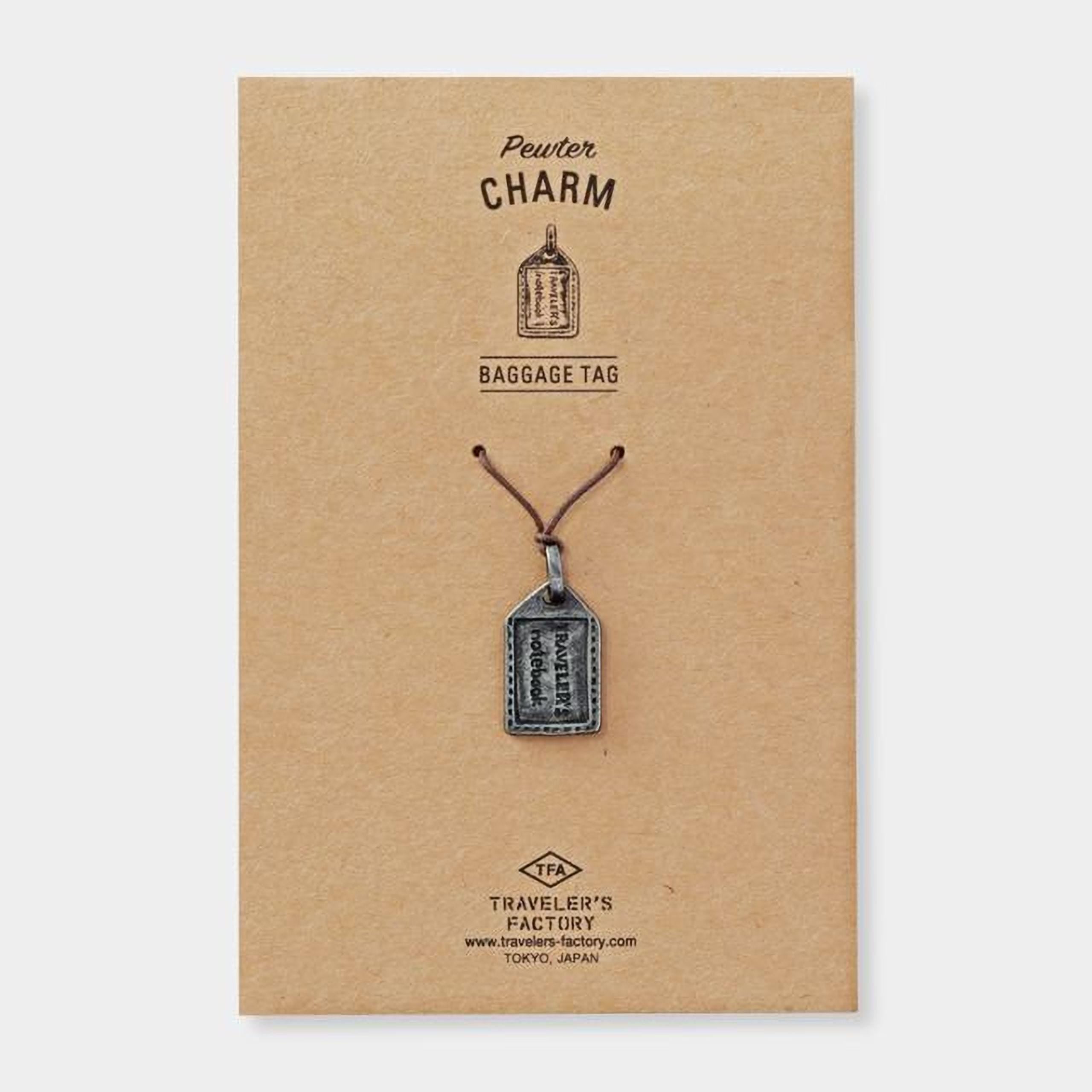 a brown cardboard box with a silver charm attached to it. The charm appears to be a small metal tag or pendant.