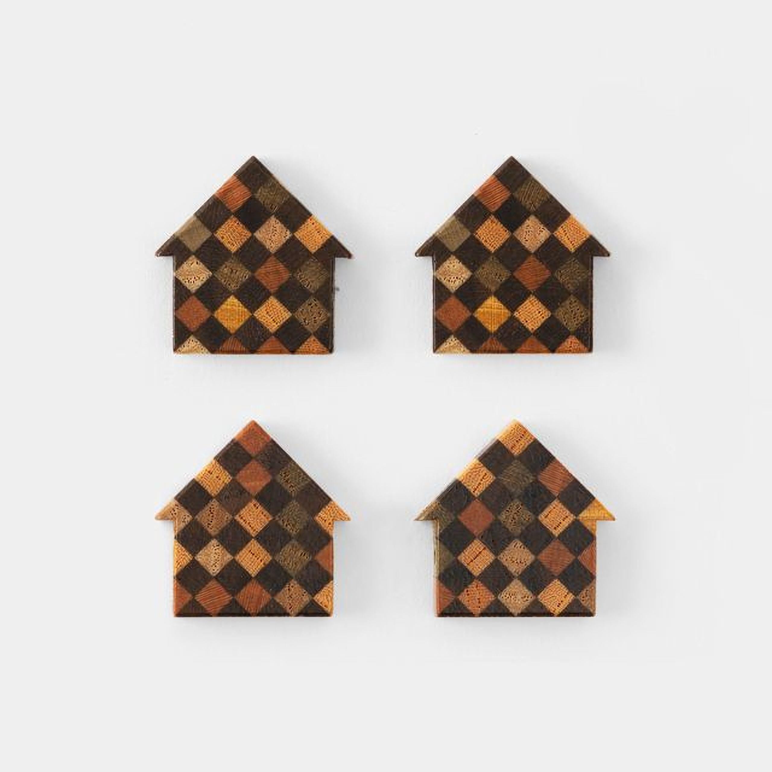 four identical wooden house-shaped objects with a checkered pattern in various shades of brown and orange.