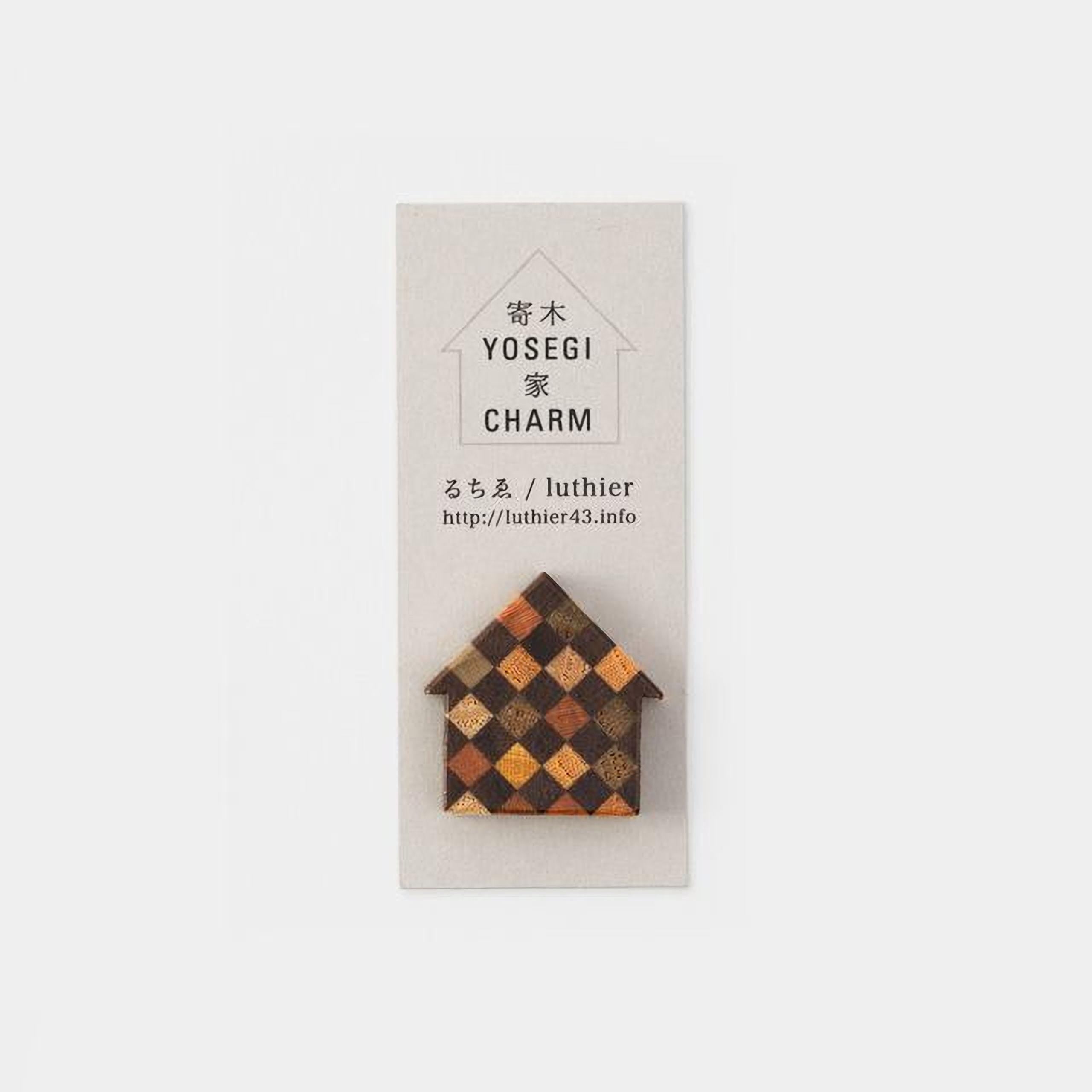 A small, wooden house-shaped charm with a checkered pattern on it, displayed on a white background.