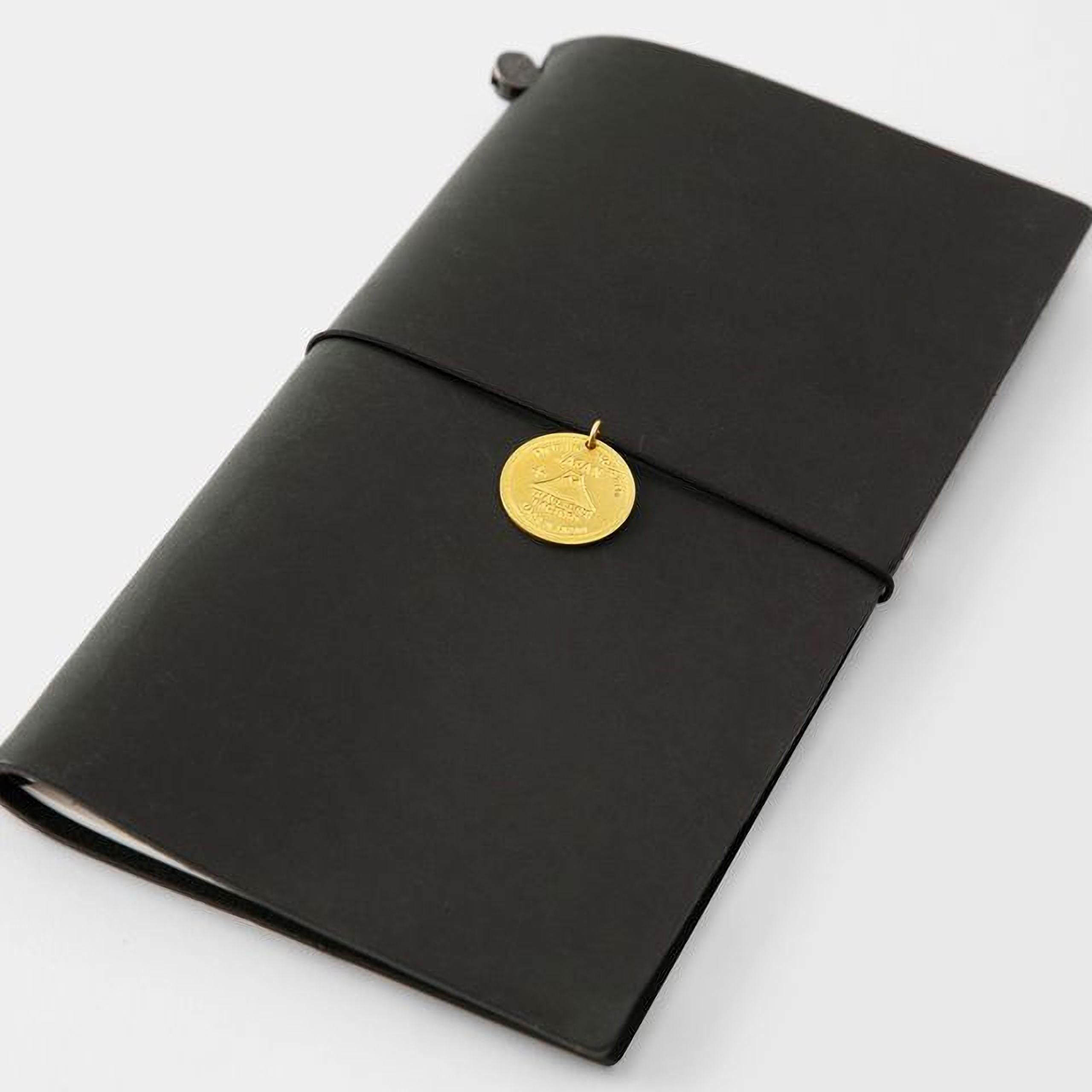 A black leather-bound notebook with a gold-colored charm attached to the cover.