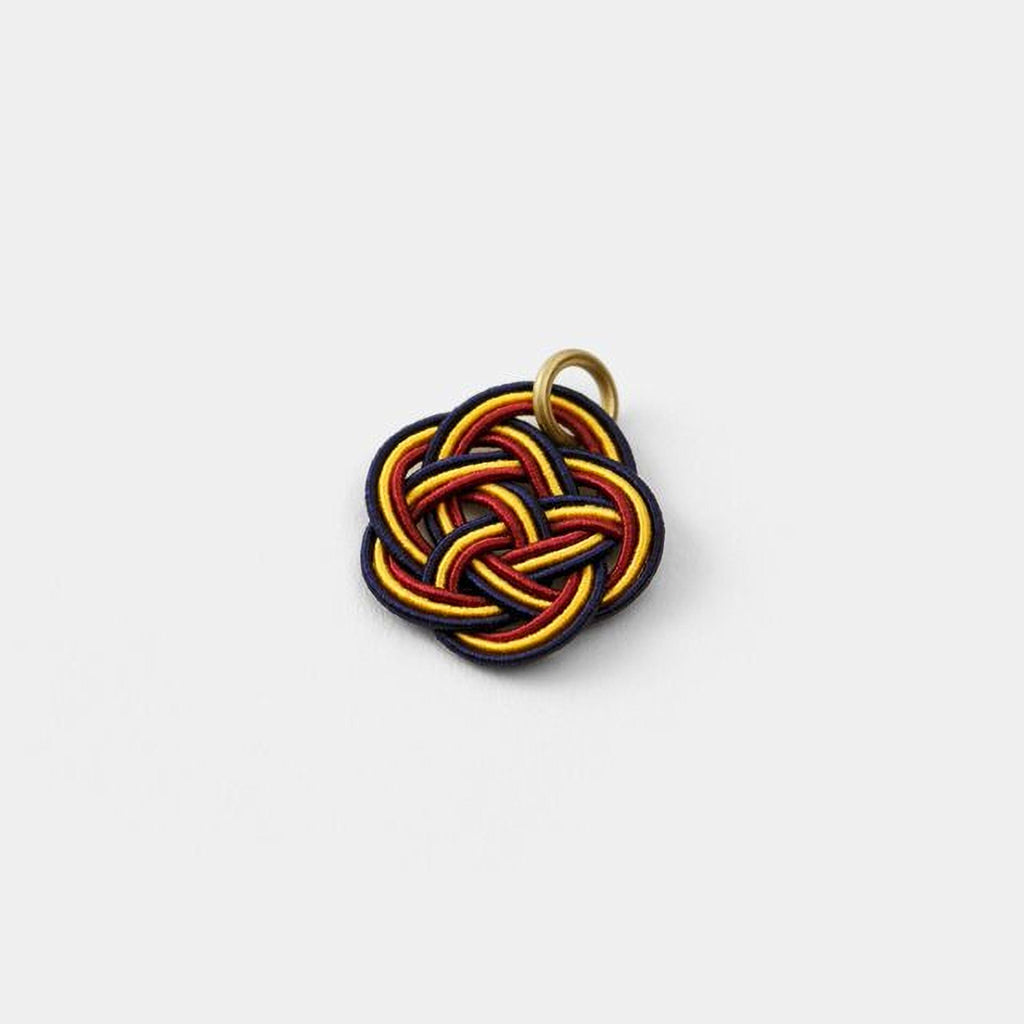 A colorful, braided piece of string or cord with a gold ring attached to it.